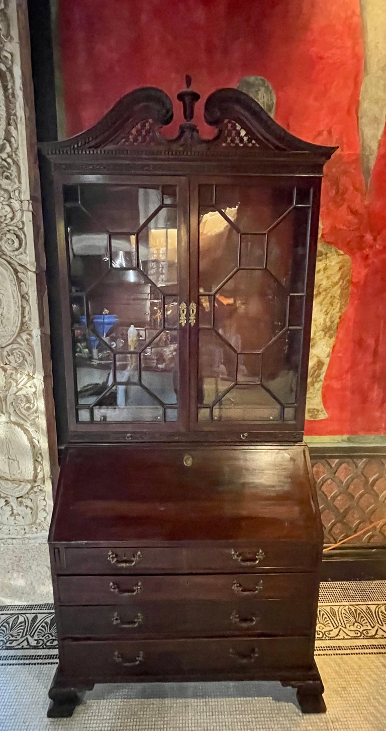 George III period mahogany Chinese Chippendale secretary bookcase, England, circa 1790. The original ogee bracket feet and the broken arch pediment top are finely carved in the Chinese taste which had reached a peek thanks to Thomas Chippendale.