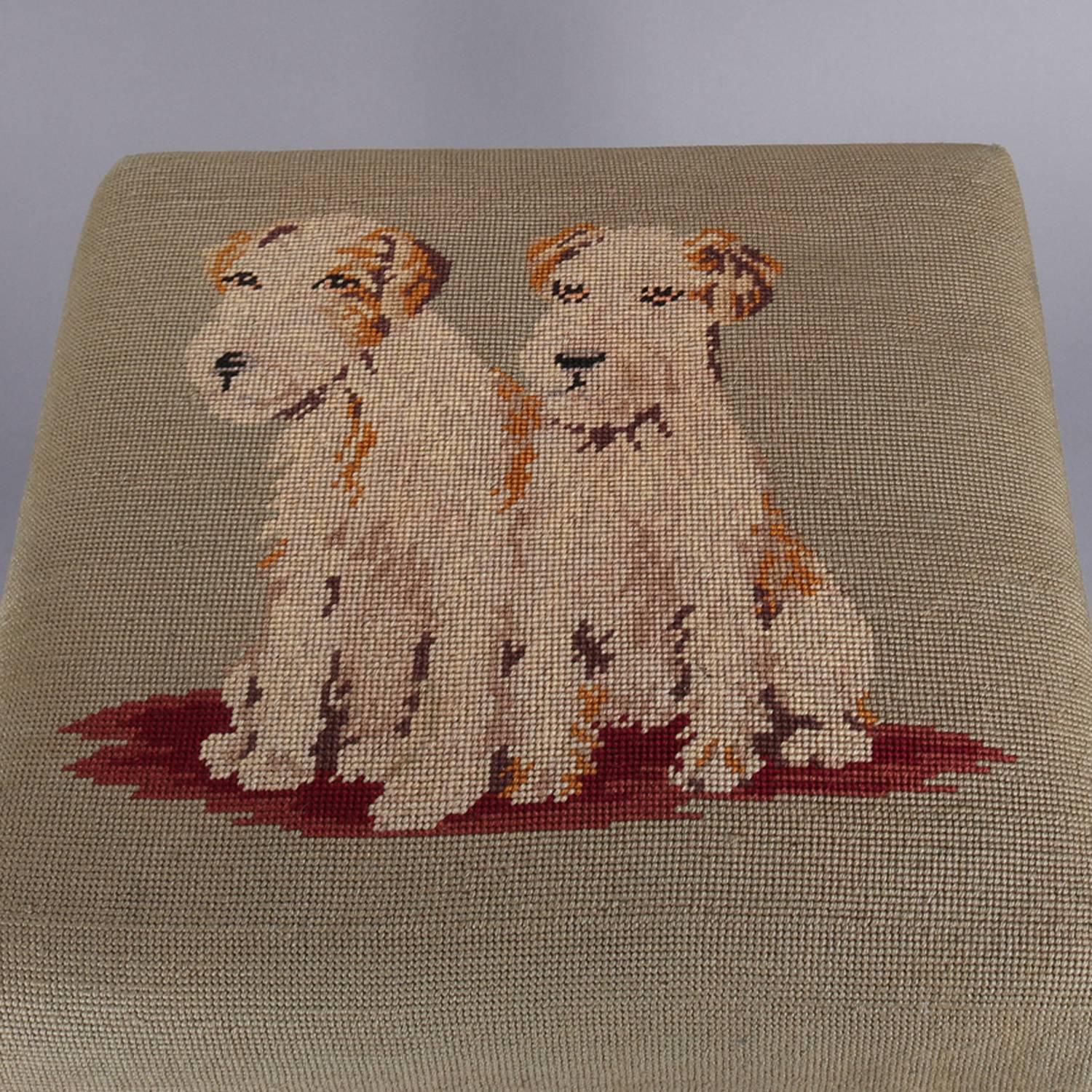 Antique Chippendale style tapestry footstool features needlepoint seat with Welsh or Airedale Terrier puppies secured with brass tacks and seated on carved mahogany cabriole legs with stylized acanthus knees and paw feet, circa 1920

Measures: 16