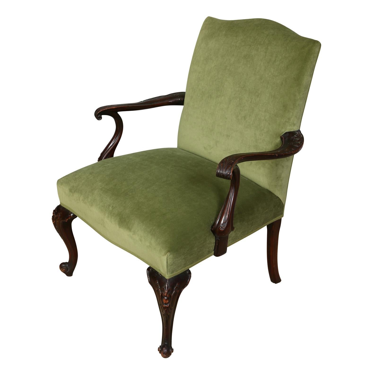 A vintage Chippendale style chair newly upholstered in rich green velvet with detailed carved and curved scroll arms and cabriole legs.