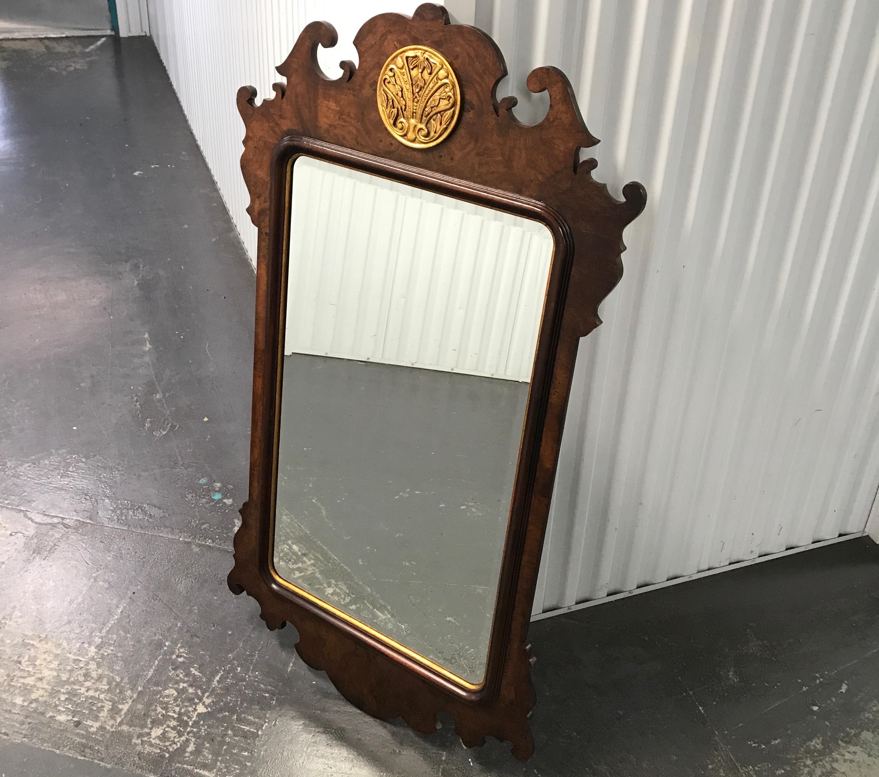 Lovely Chippendale style burlwood mirror adorned at top with gilded medallion.