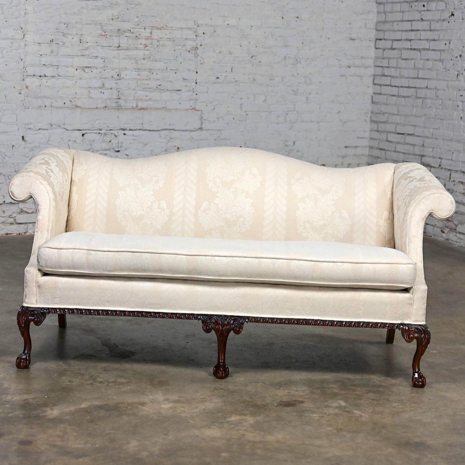 Marvelous vintage Chippendale style camelback settee sofa or loveseat with walnut toned wood base trim, cabriole legs with eagle ball & claw feet, and off-white tone on tone striped floral pattern Damask fabric on frame and poly wrapped foam single
