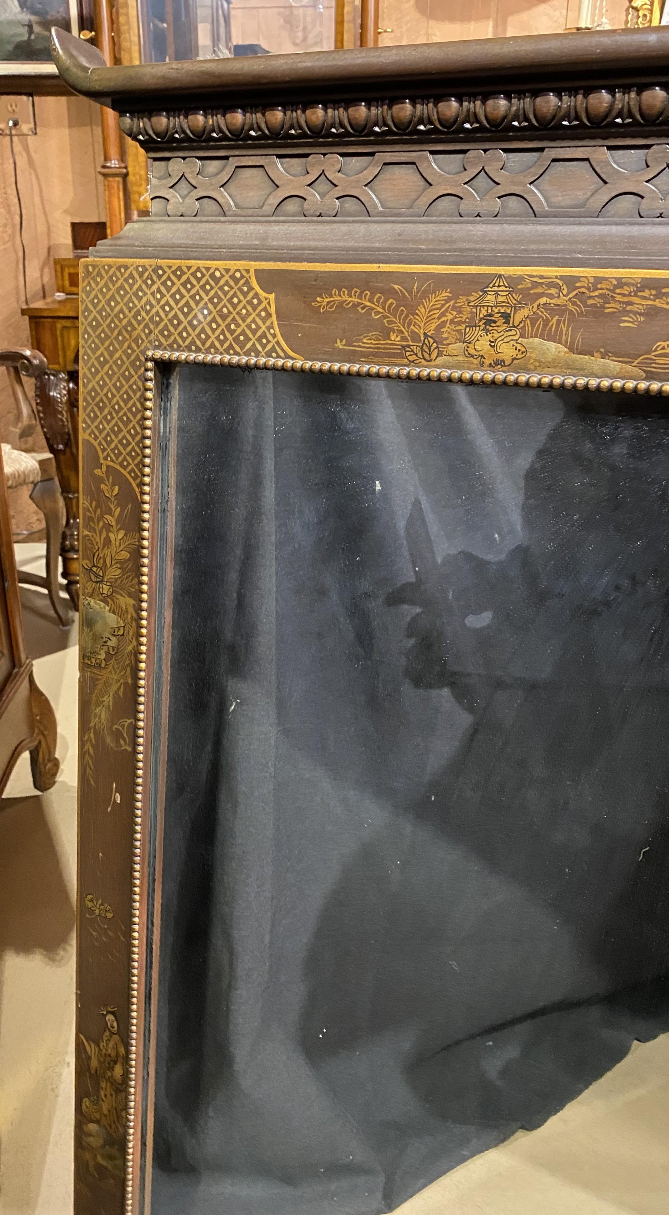 Joli miroir carré en bois dur teinté doré, de style Chippendale, avec crête sculptée, bordure peinte de scènes de genre, motifs géométriques, accents géométriques sculptés dans les coins, et fine bordure intérieure en sphérule dorée. Probablement