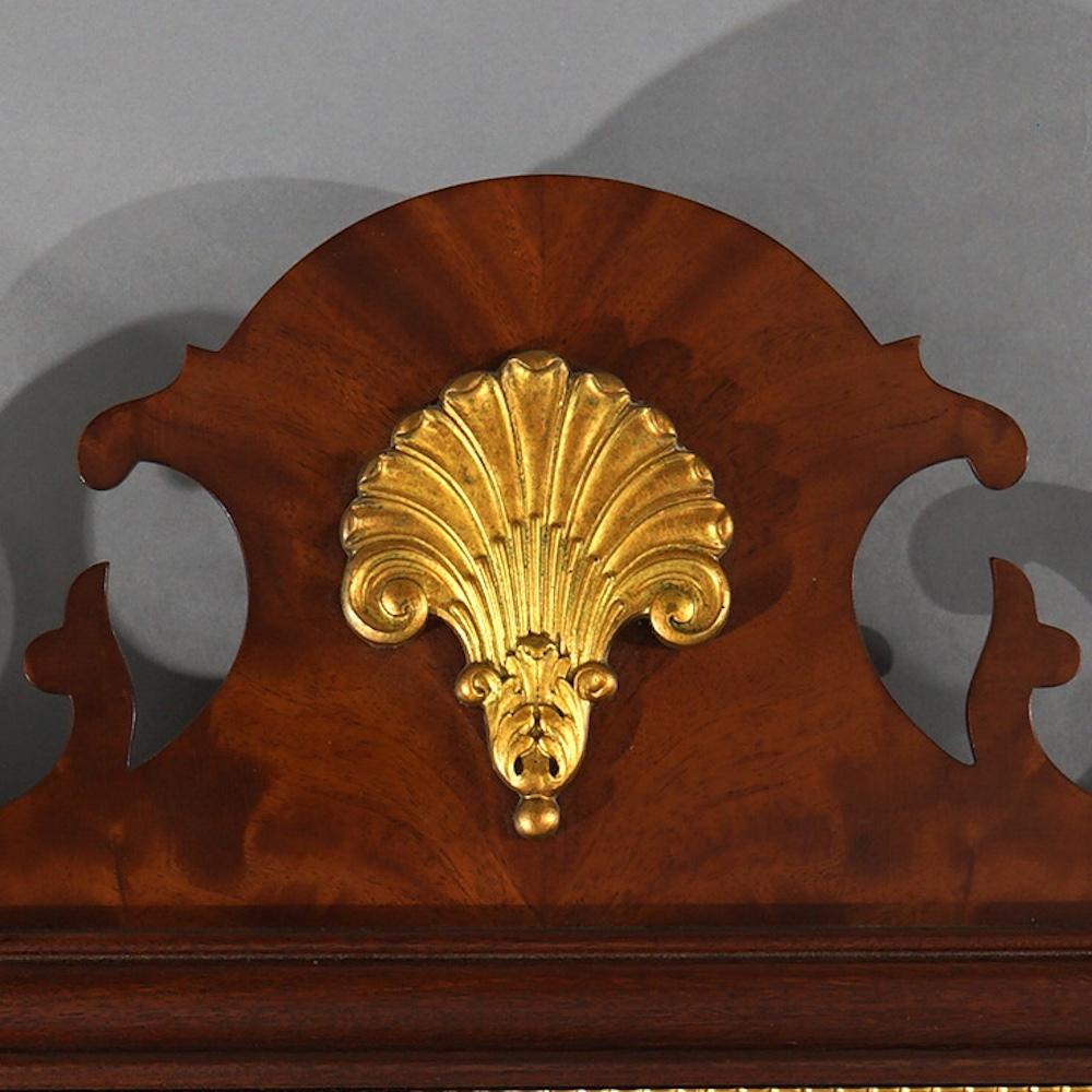 A Chippendale style wall mirror by Council offers shaped scroll form mahogany frame with giltwood decoration, maker label en verso as photographed, 20th century

Measures- 51