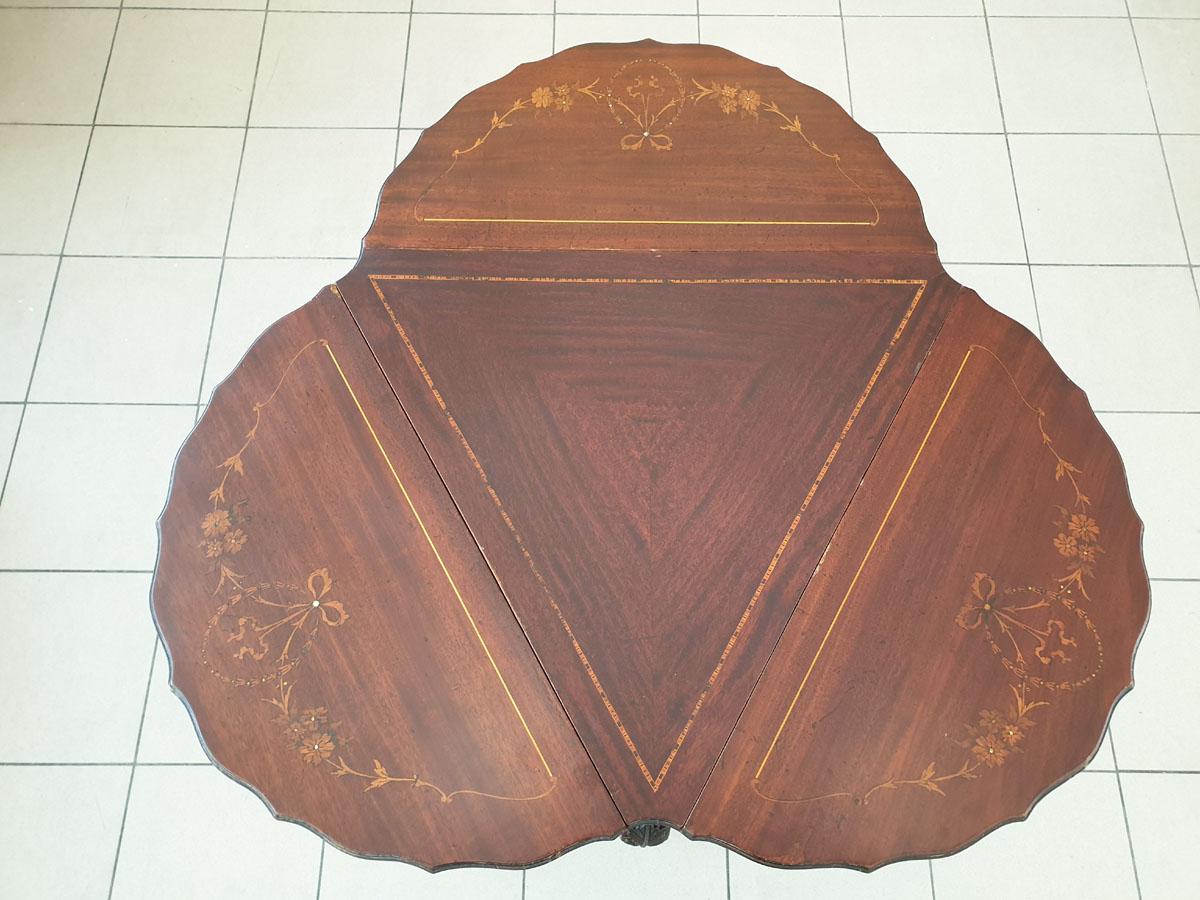An unusual piece of furniture in the style of Chippendale, a delicate table with a folding top in a fancy shape.

The unfolded top has the shape of 