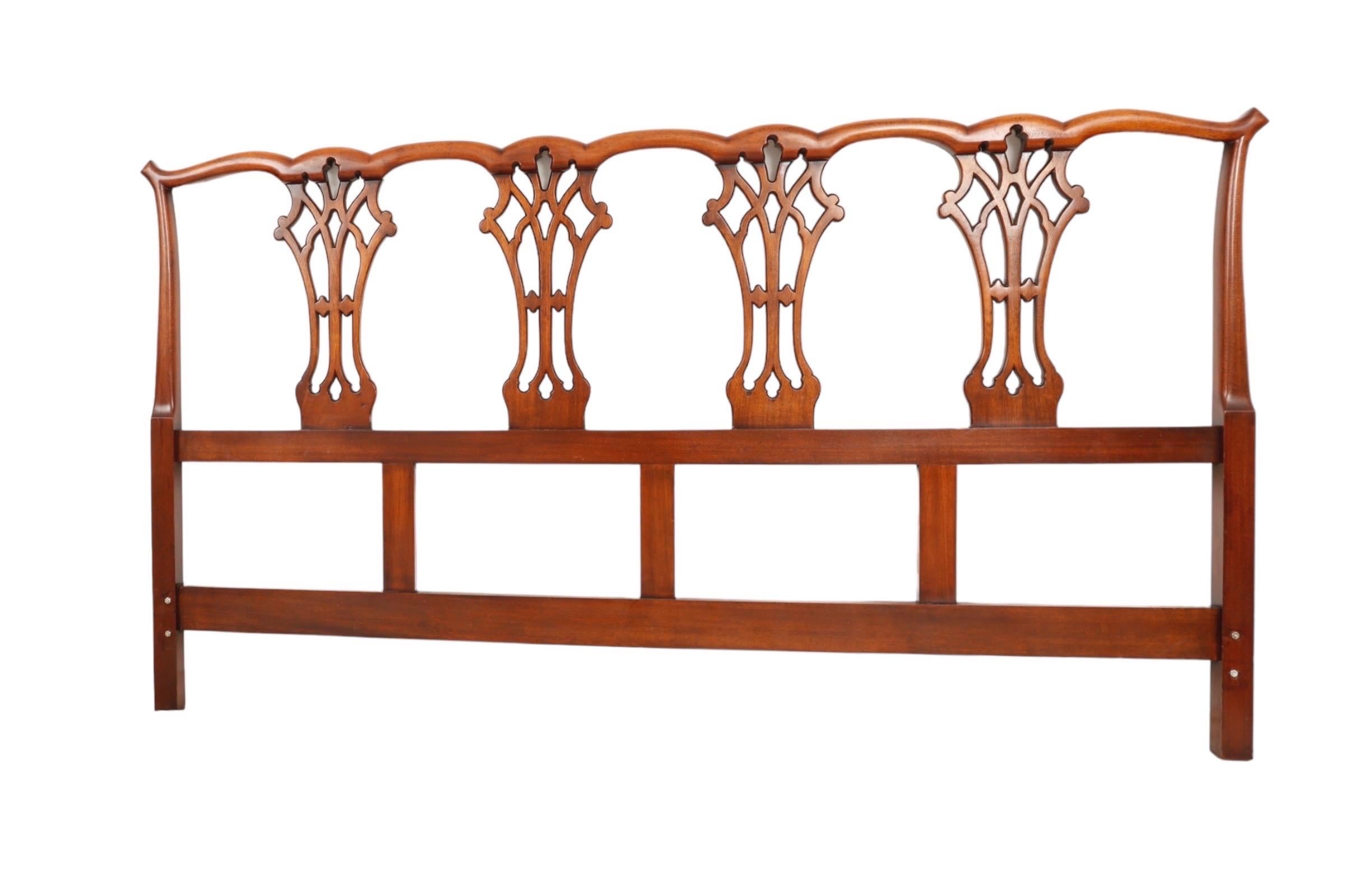 A king size Chippendale style headboard made of solid mahogany. A serpentine crest rail is supported with four simply carved, pierced, back splats.