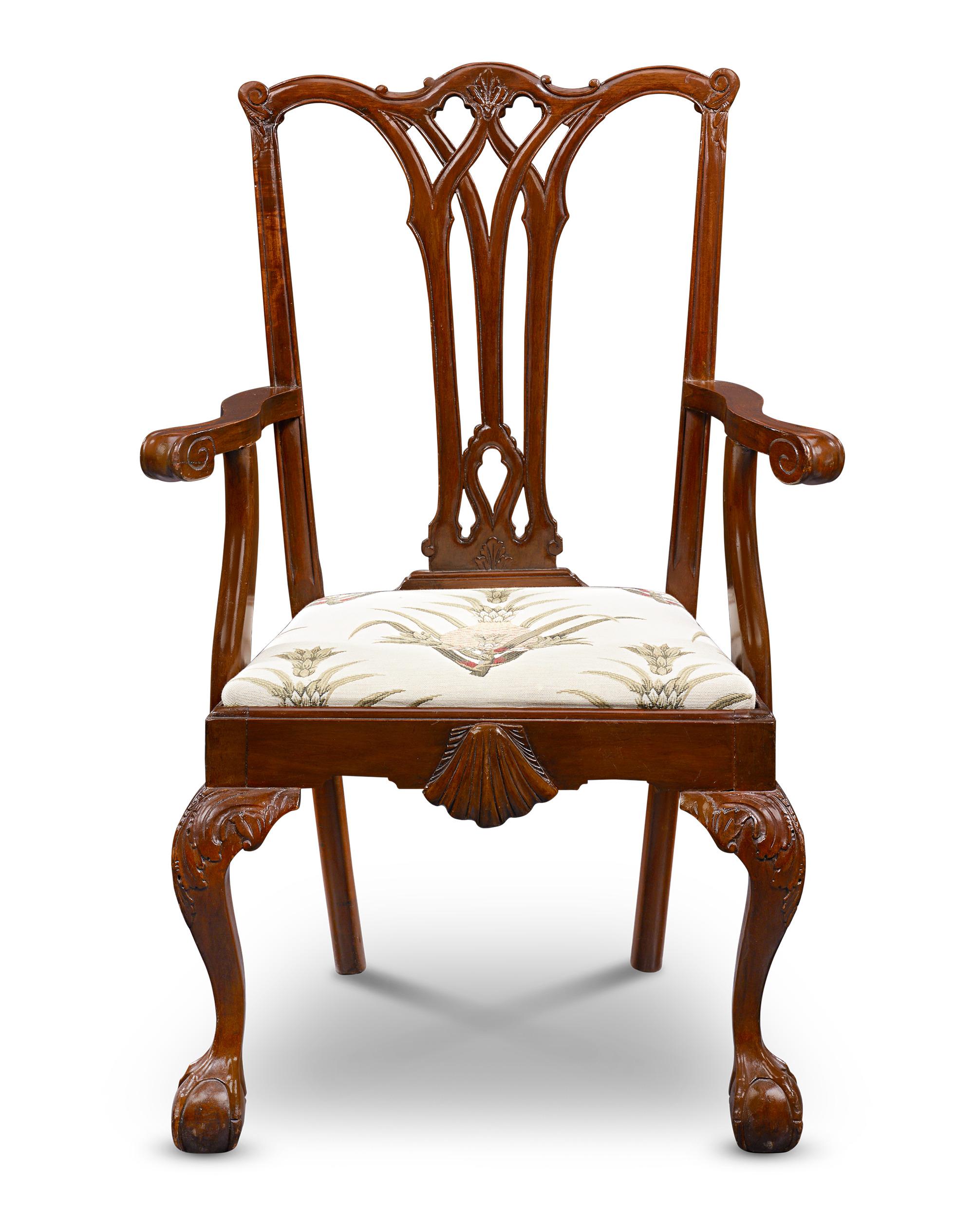 Este exquisito sillón de caoba con respaldo de cinta personifica la elegancia y sofisticación asociadas a los diseños de Thomas Chippendale. Elementos distintivos como la talla superior, los pies de bola y garra y los respaldos de tablilla