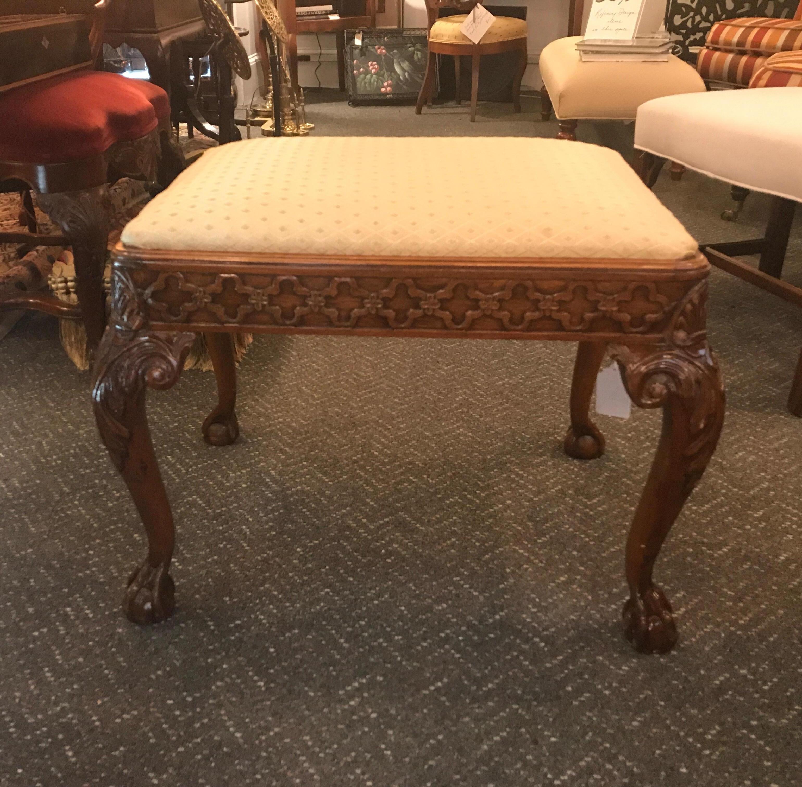 A carved mahogany Chippendale style bench with new fabric seat. The ball and claw carved legs with carved apron all around.