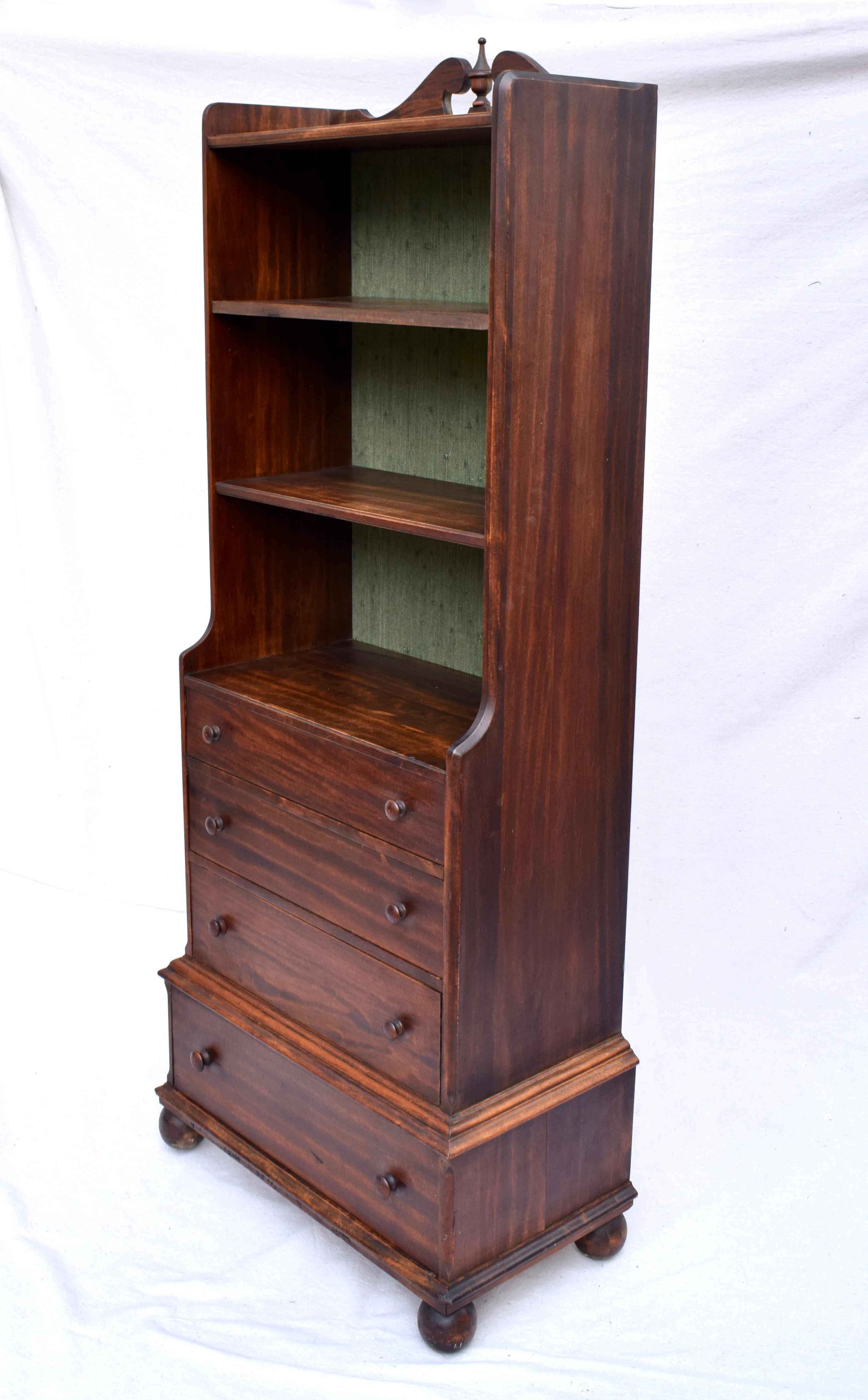 A 20th c.. Mahogany bookcase with two removable shelves and new custom lined green grasscloth interior, four dovetail drawers terminating on marvelous cannon ball feet.