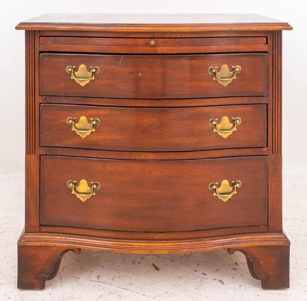 American Chippendale style mahogany low chest of drawers or nightstand, having three drawers and one sliding panel, raised on carved bracket feet. 

Dealer: S138XX