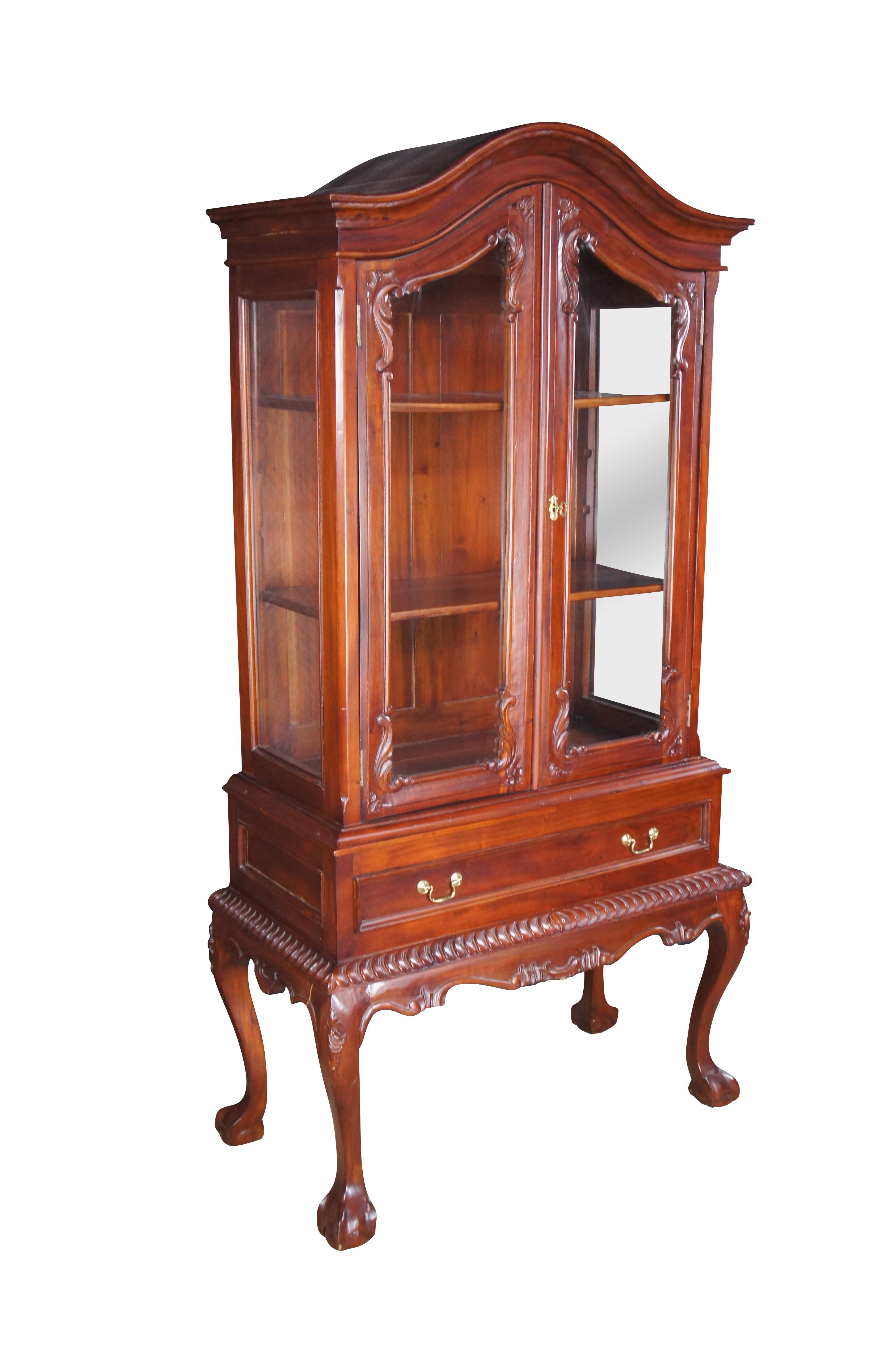 Vetrina/armadio in mogano d'epoca in stile Chippendale con piano a cupola e accenti d'acanto.  Il mobile ha un grande cassetto inferiore ed è sostenuto da piedini a sfera in stile Queen Anne.  Include una chiave funzionante.

Dimensioni:
20