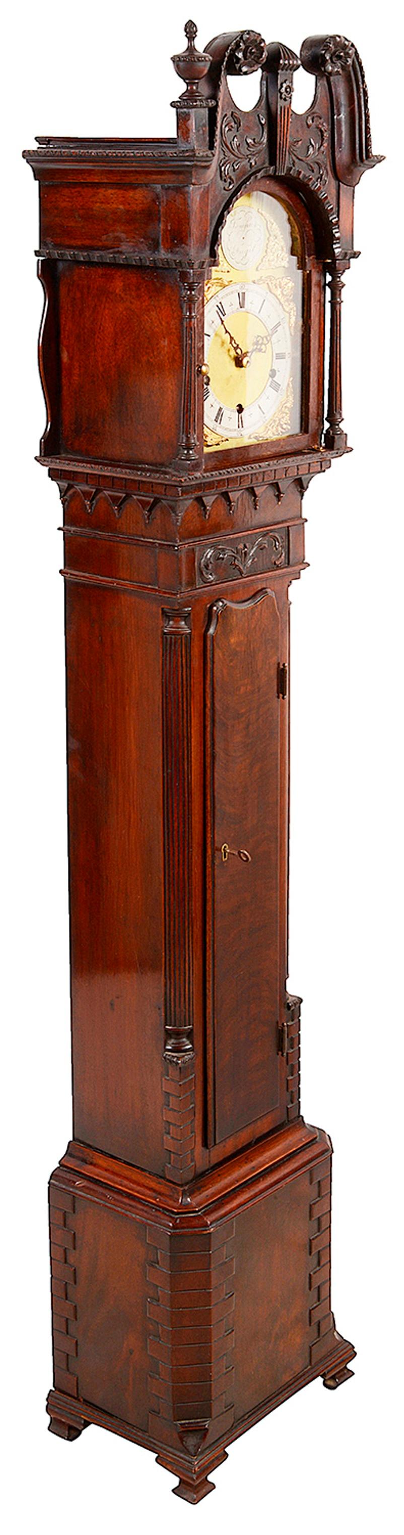 A very good quality early 20th century mahogany Chippendale influenced grandmother clock, having wonderful carved decoration to the swan neck pediment hood, an arched brass dial, eight day duration, three train chiming movement. Canted corners to