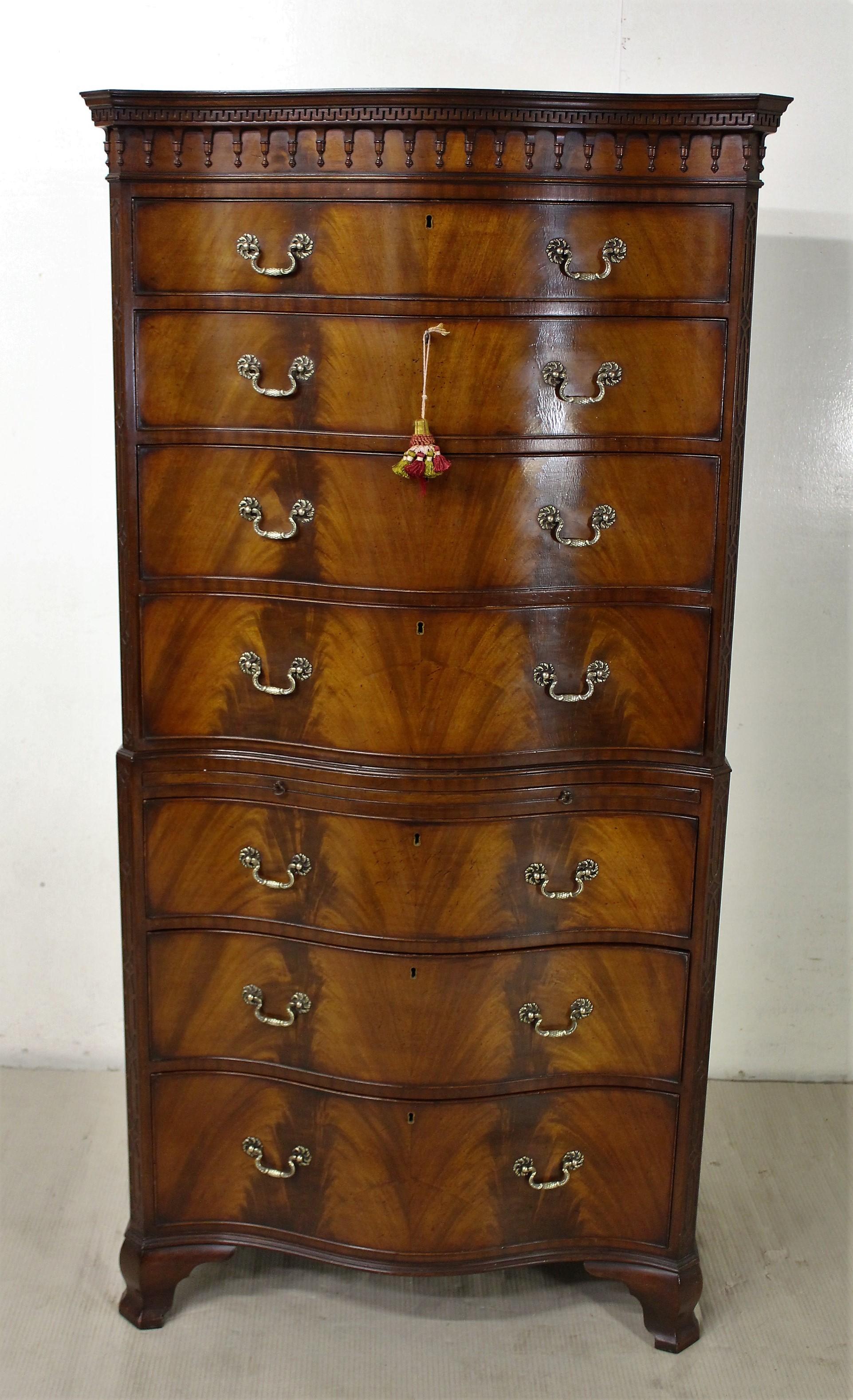 A splendid flame mahogany serpentine fronted chest on chest, or tallboy, in the manner of Thomas Chippendale. Well constructed in solid mahogany with attractive flame mahogany veneers. The cornice with Greek key moldings and drop pendants. With
