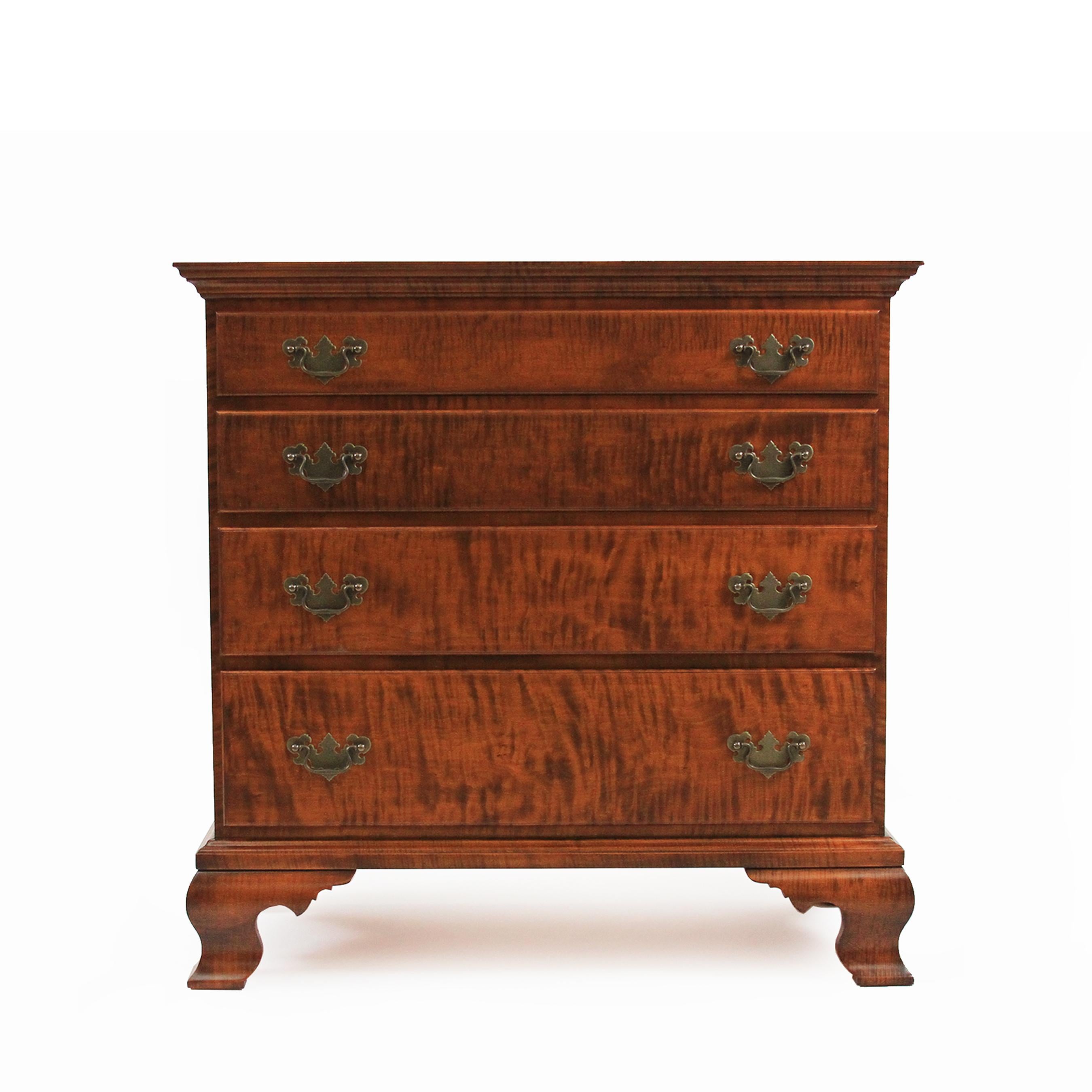 Our Chippendale tiger maple four-drawer dresser is shown in our amber tiger stain with dovetailed drawer cases, OG bracket feet and Chippendale brass pulls available polished or antiqued with matching escutcheons. Custom sizes, wood types and