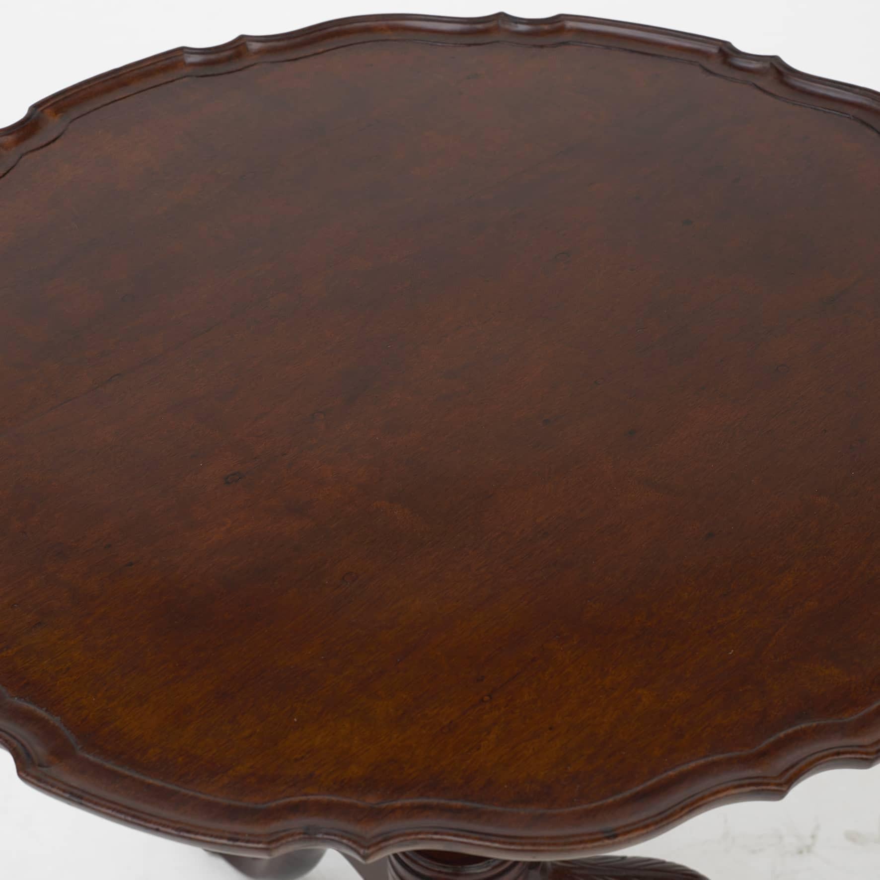 English Chippendale Tilt-top table i mahogany with tripod base.
Circular top with a carved scalloped molded edge.
Supported on a carved three foot pedestal base over a turned stem.

England 1750-1770.