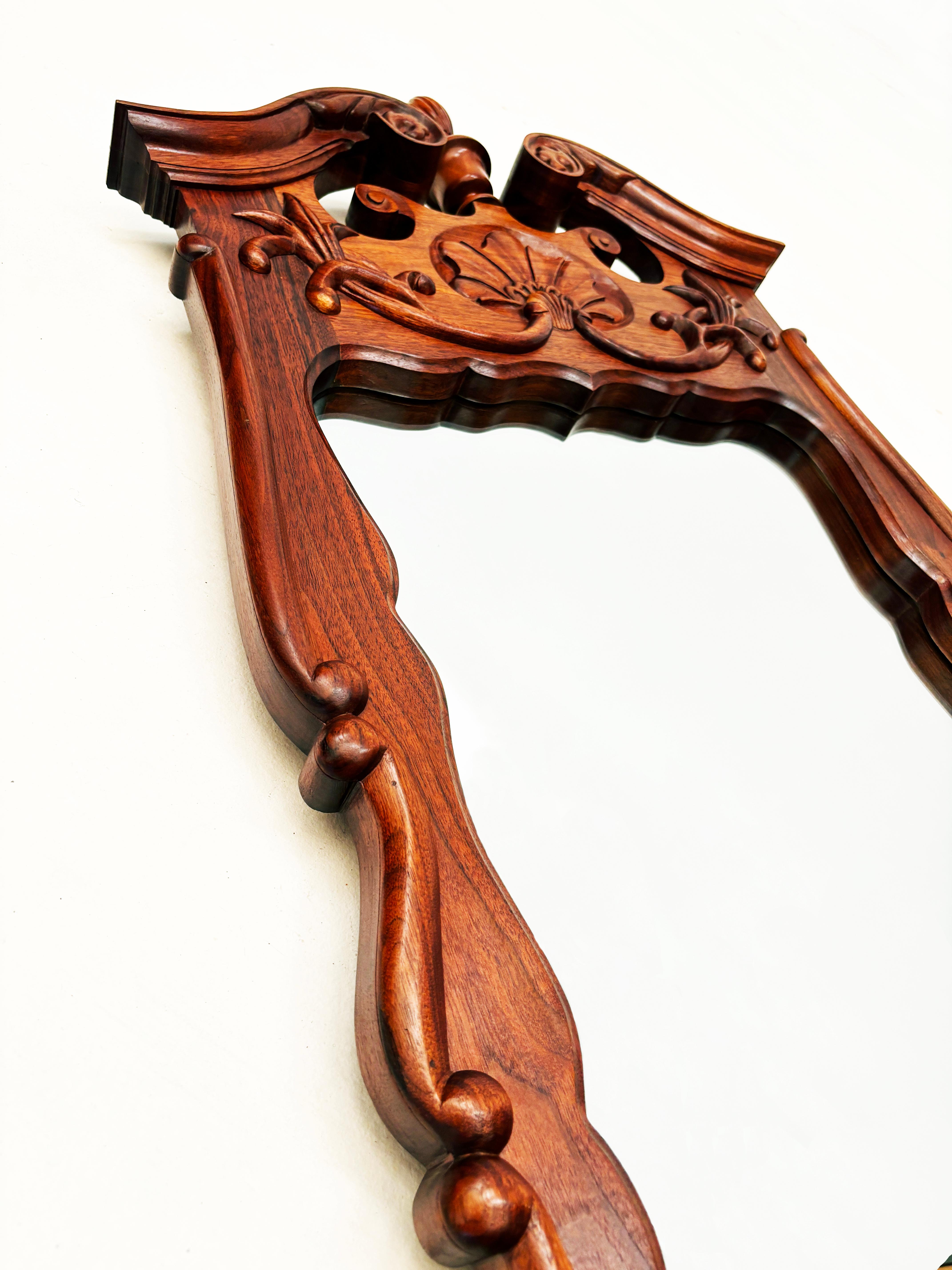 This stunning custom-made walnut mirror was done in a hand-carved Chippendale style that's unique in shape and detail. Extremely stout in construction, the rich characteristics of the walnut combined with the custom design and simple, yet ornate