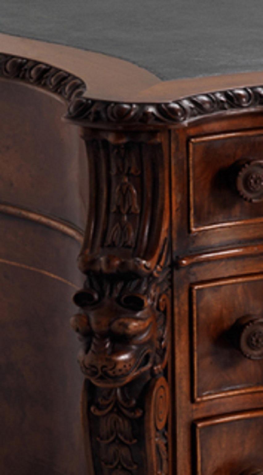 The egg-and-dart moulded and serpentine shaped top with leather writing surface, the opposing sides fitted with a frieze drawer flanked by four graduated drawers to each pedestal, lion mask and acanthus canted angles, on paw feet.

Please note that
