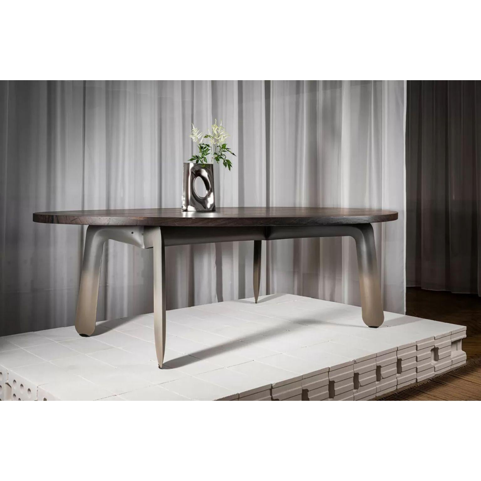 Chippensteel Table by Zieta
Dimensions: D 157 x W 250 x H 76 cm.
Materials: carbon steel base and bog oak top.

The CHIPPENSTEEL TABLE is a flashback to the first work in the internal pressure forming of steel. The object in its form and name