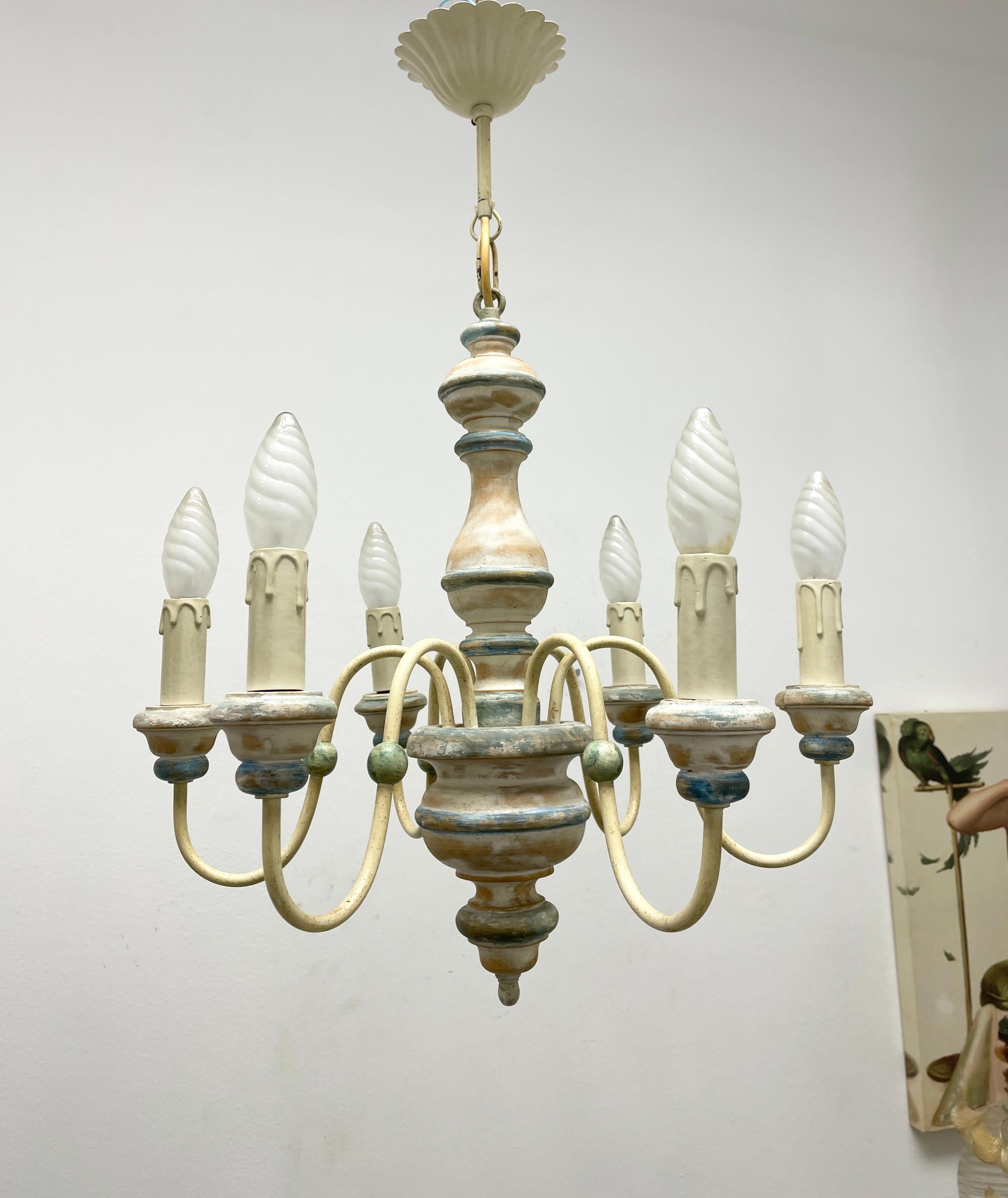 Add a touch of opulence to your home with this charming chandelier! Perfect wood and metal chandelier to enhance any chic or eclectic home. The beautiful chippy white and blue colors give this chandelier a characterful expression. We'd love to see