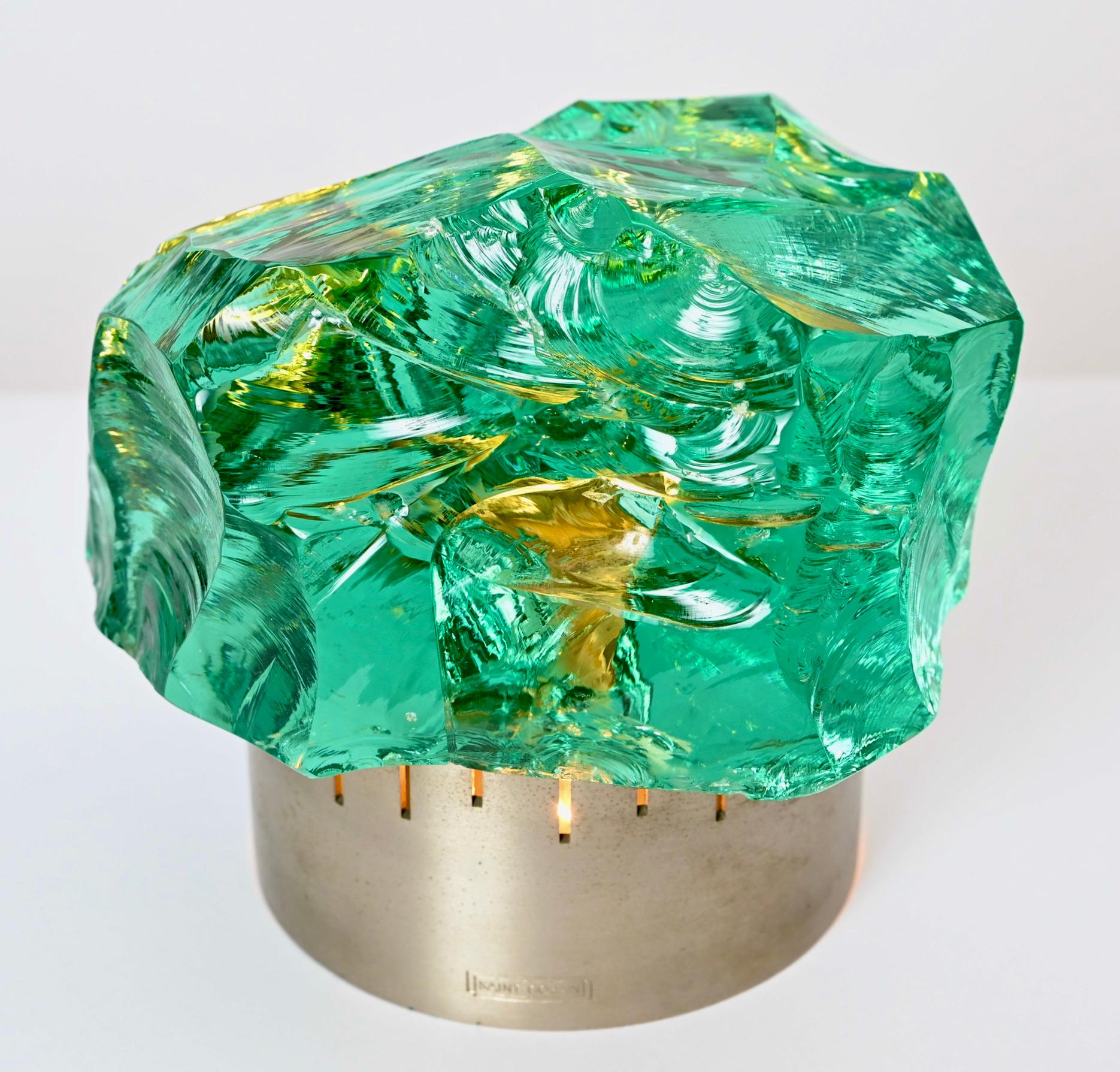 This beautiful crystal table lamp was designed by Max Ingrand for the renowned French glass company, Saint-Gobain. Produced in the 1960s, the chiseled emerald green coloured crystal sits on a brushed, nickel-plated brass circular base. Each one of