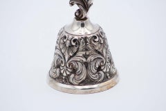 Chiseled silver bell with feathers and plant-based elements