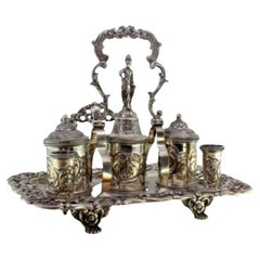 Chiseled silver inkwell with cut-out tray, three tanks, bell 
claw feet