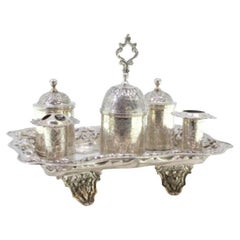 Chiseled silver inkwell with two pen holders, tanks, bell 
floral feet