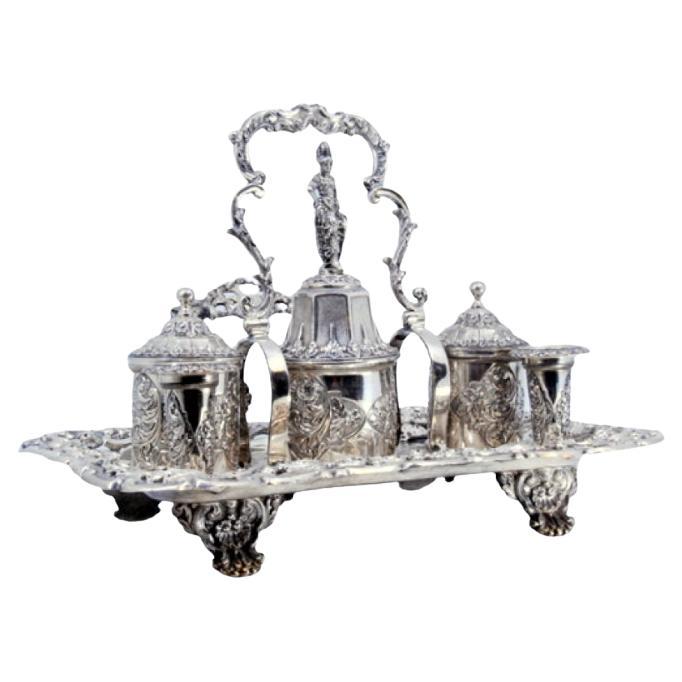 Chiseled silver inkwell with two pen holders, two tanks 
bell