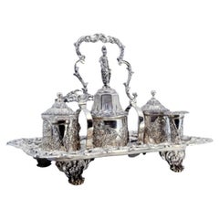 Chiseled silver inkwell with two pen holders, two tanks 
bell