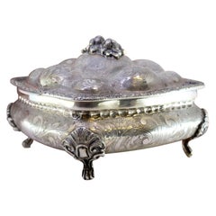 Chiseled silver jewelry box with bouquet-shaped lid handle and gold interior