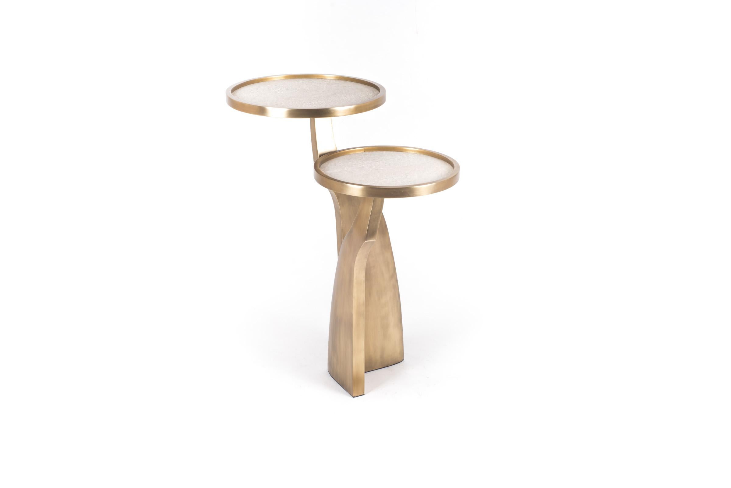 The Chital 2-top side table is both dramatic and organic it’s unique design. The cream shagreen inlaid 2-top sits at different levels, on a pair of ethereal and sculptural bronze-patina brass legs. This piece makes for the perfect end table and is
