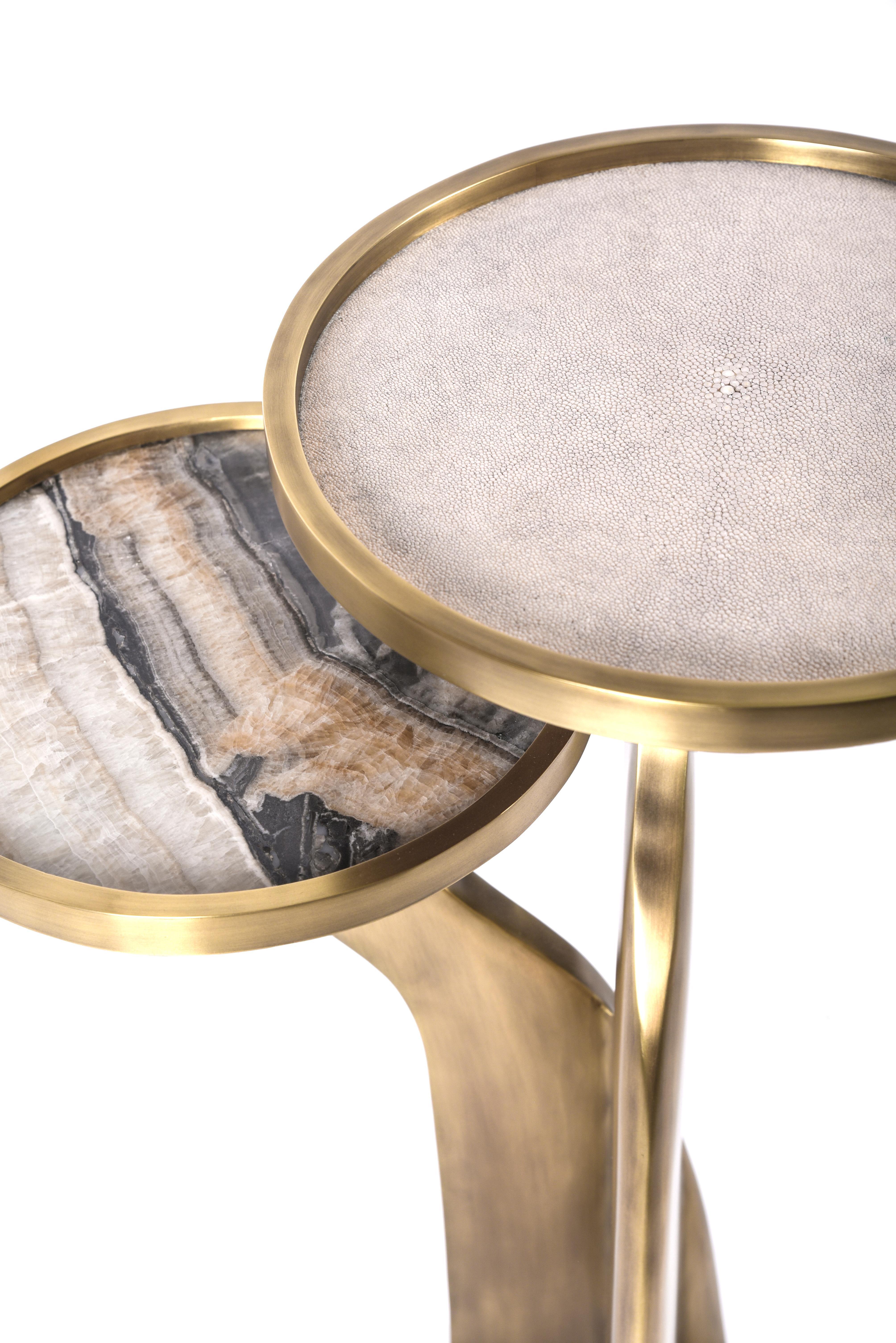 The Chital 2-top side table is both dramatic and organic it’s unique design. The 2-top mixture of cream shagreen and onyx, sits on a pair of ethereal and sculptural legs that are fully inlaid in bronze-patina brass. This piece makes for the perfect