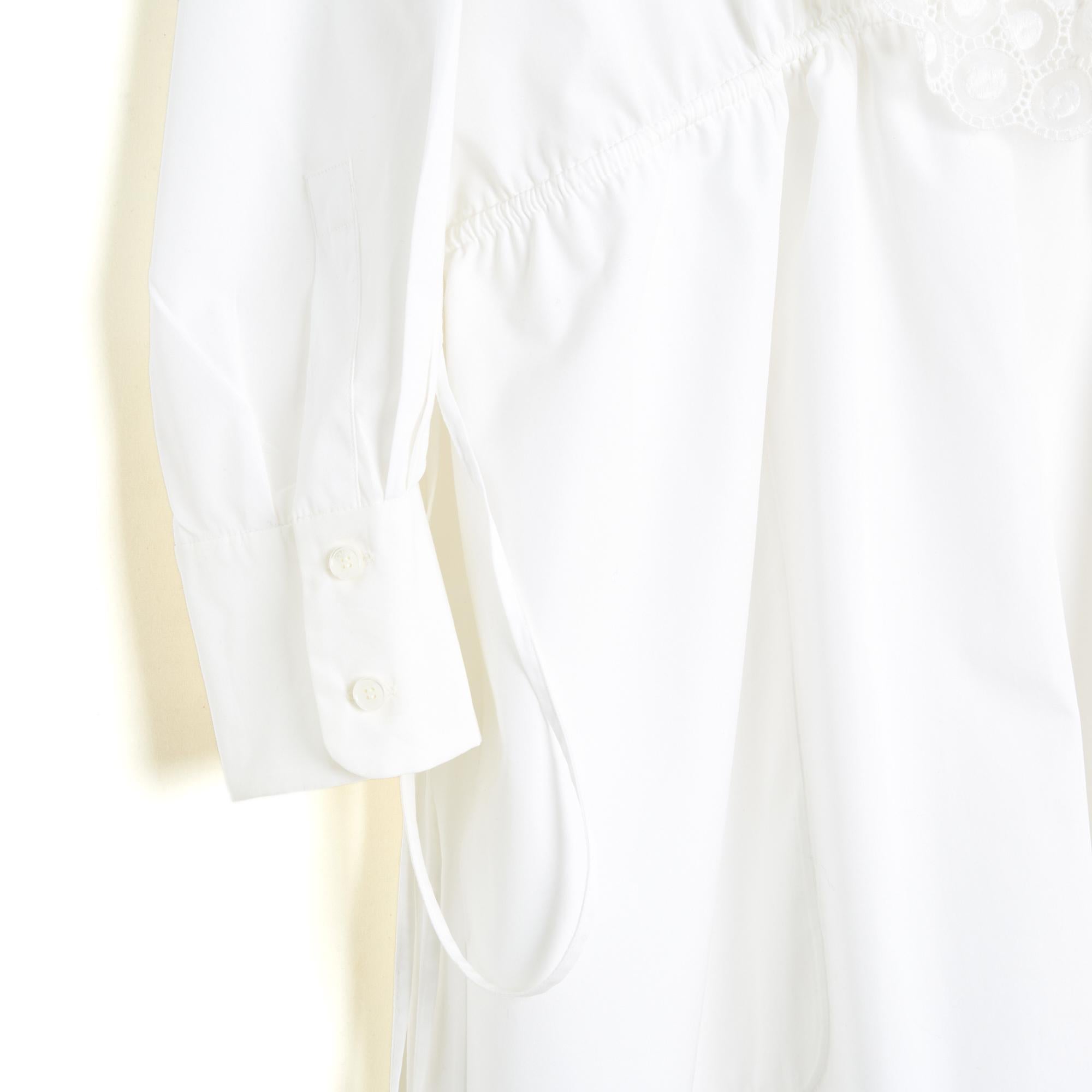 Vestido Chloé colección SS2018 estilo camisero de popelina de algodón blanco, plastrón con volantes de encaje inglés cerrado por 7 botones hasta la cintura, 2 lazos de ajuste a cada lado de la cintura, 2 bolsillos con aberturas a los lados, mangas