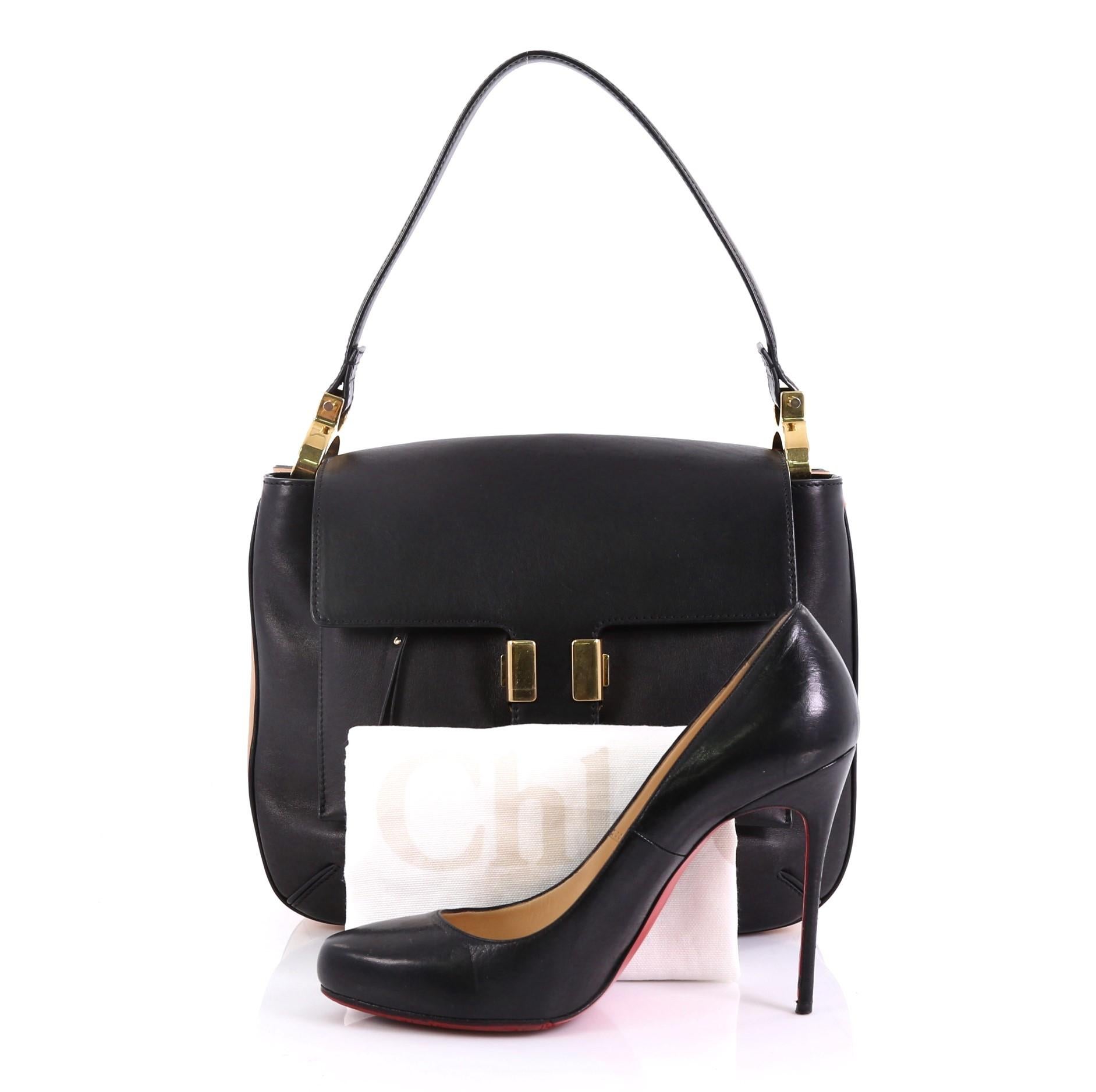 This Chloe Amelia Shoulder Bag Leather Medium, crafted in black and beige leather, features a single lopped leather strap with rings and gold-tone hardware. Its clasp closure opens to a black leather interior with two compartments and slip pocket.