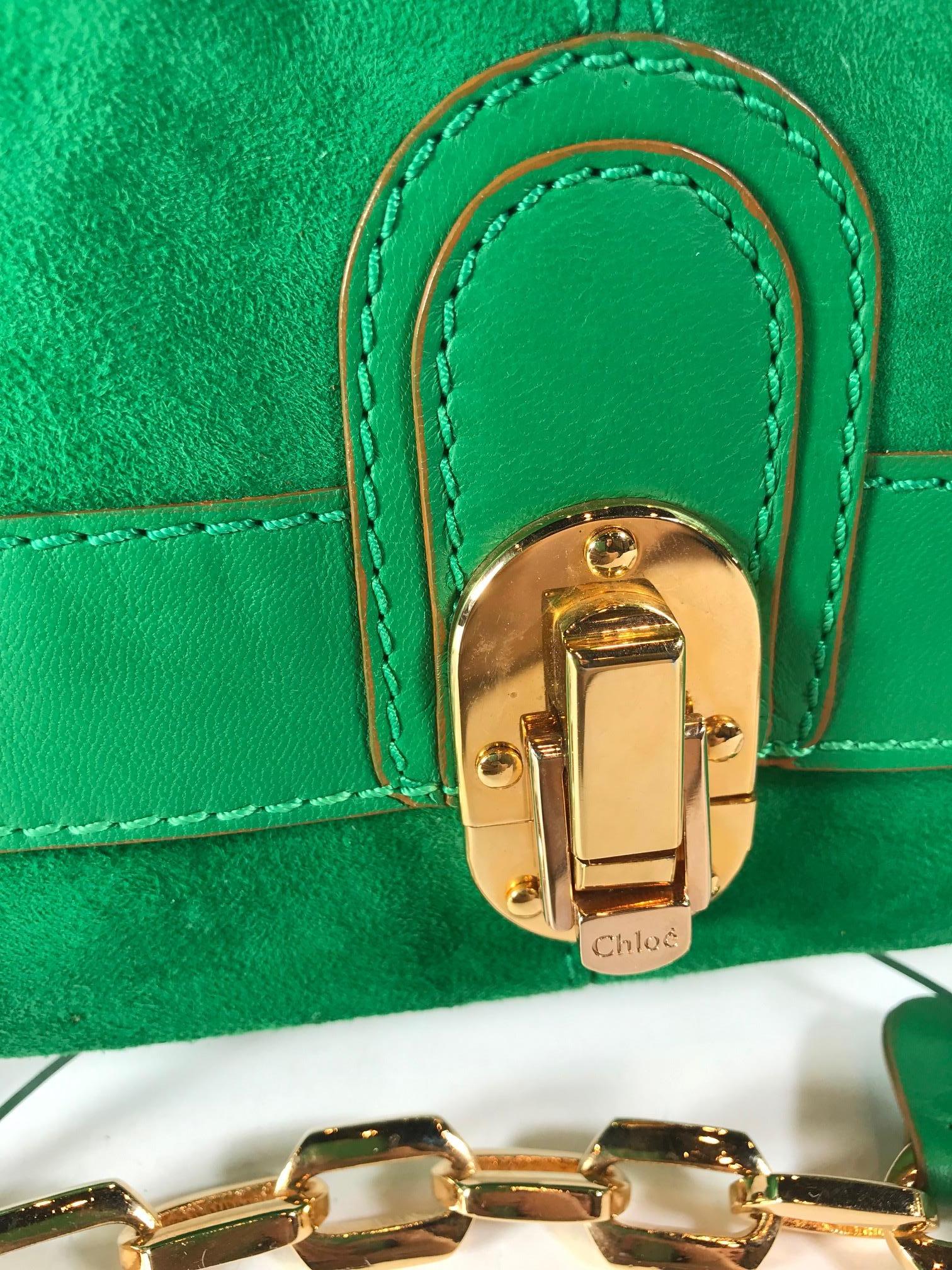 From the 2008 collection. Bottle green suede and leather detail. Gold-tone hardware. Front flap closure. Single chain link shoulder strap. Nude pink satin interior. One interior zippered pocket.
