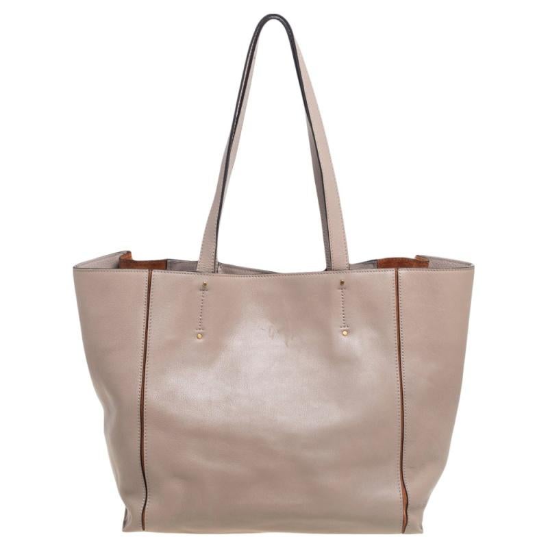 Effortlessly carry all your essentials in style with this Milo tote from Chloe. It is made using beige-brown leather and suede on the exterior with gold-toned hardware, contrast stitch detailing, and zipper accents highlighting its shape. Give your