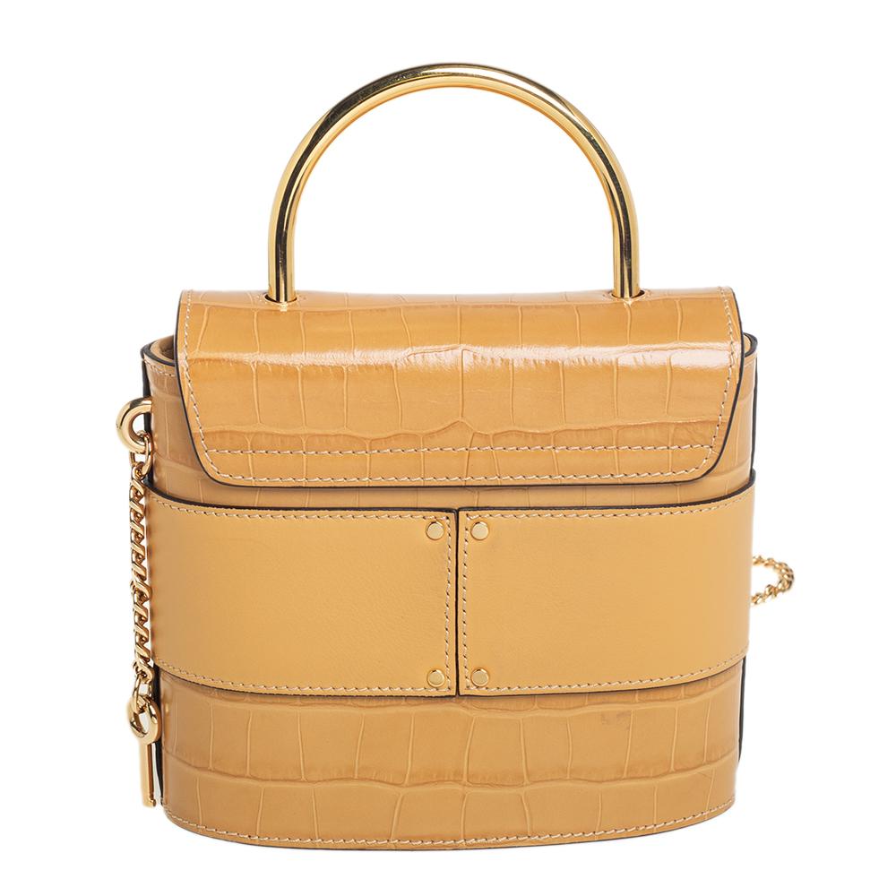 With an affinity to create chic bags that look like works of art, Chloe brings this Aby Lock bag that is just a masterpiece. Crafted from croc-embossed leather, it presents itself in a beige hue. It is styled with a front flap that carries the brand