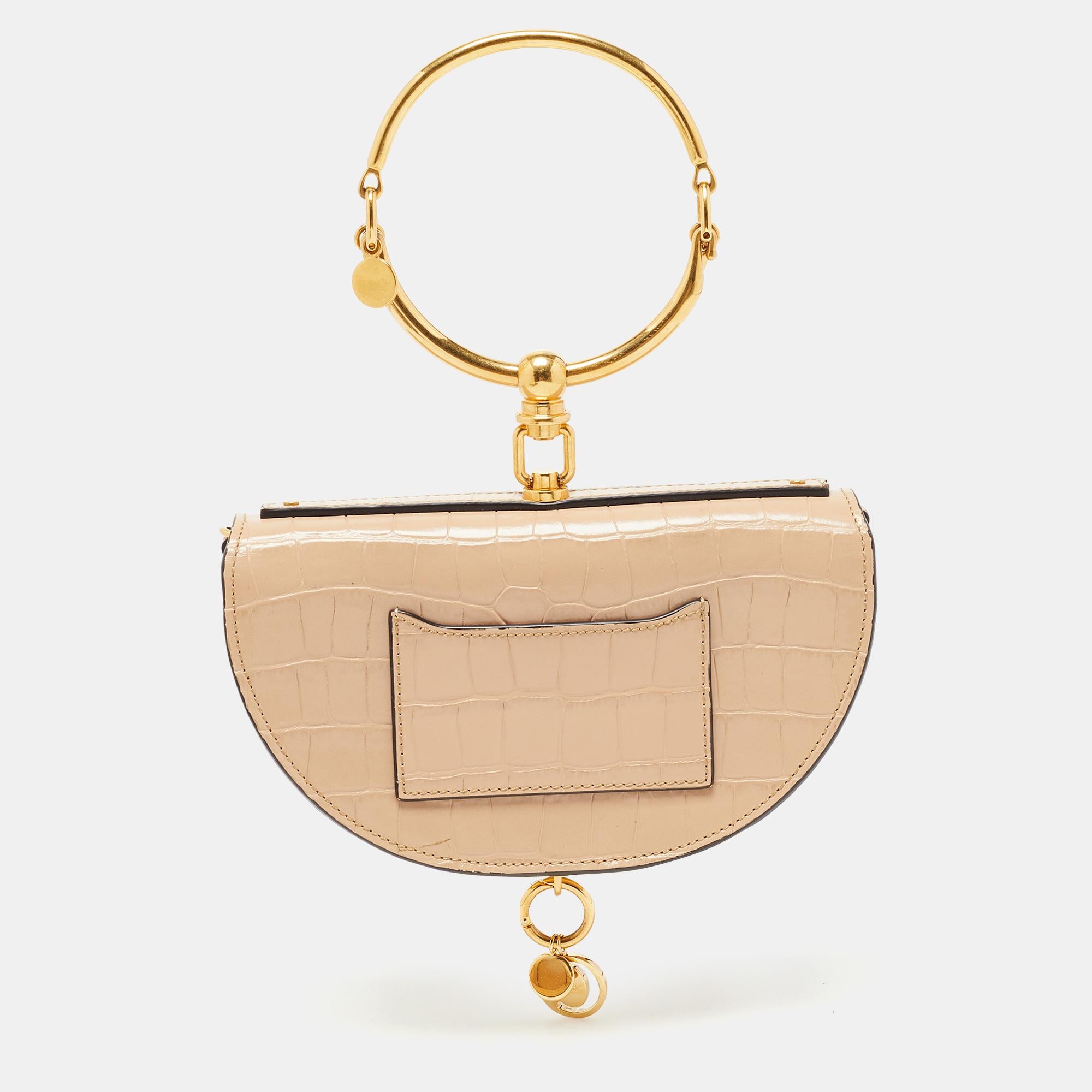 This Nile bag by Chloe can become your most favorite bag, thanks to its unique shape and the bracelet handle. It has been crafted from leather and styled with a front flap that opens to a leather interior housing an open compartment and a slip