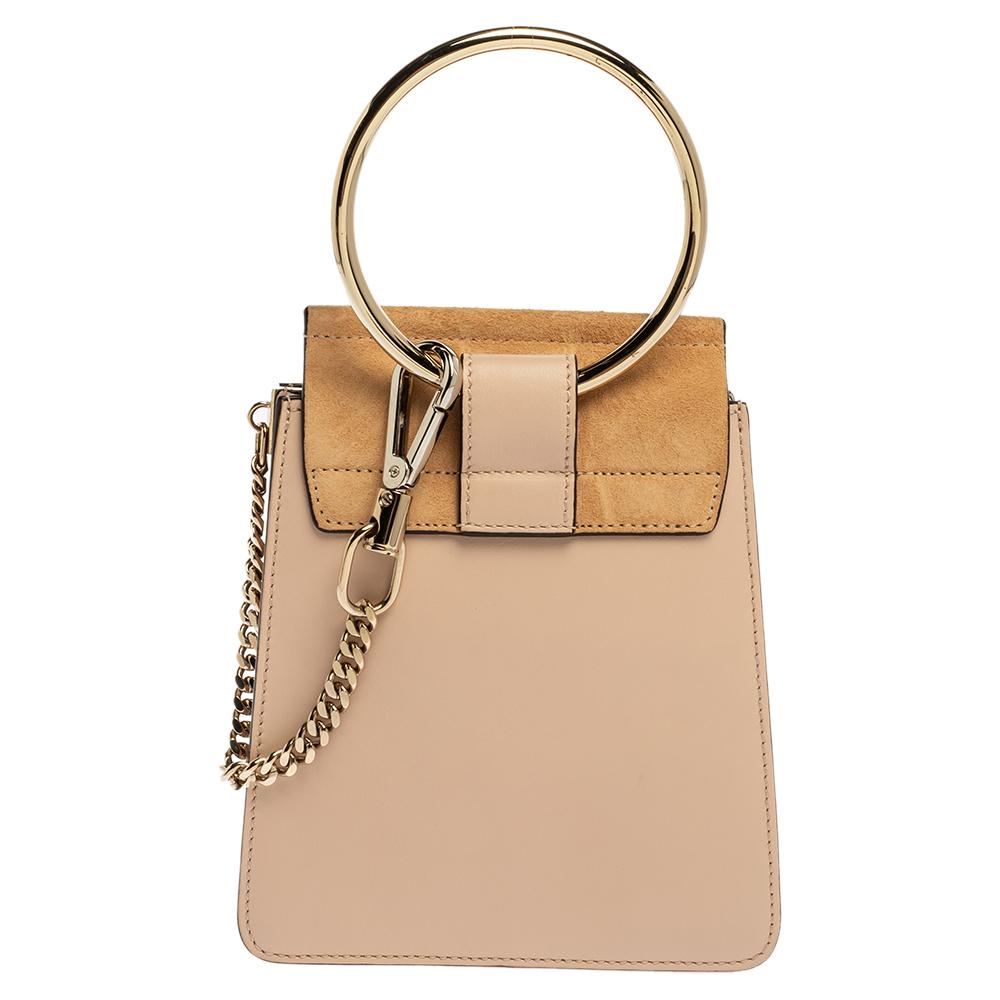 This Chloe Mini Faye bag exudes style, modernity and class in equal measures. It comes crafted from beige leather and suede and styled with a front flap that carries a circular ring accent. It opens to a suede-lined spacious interior and is held by