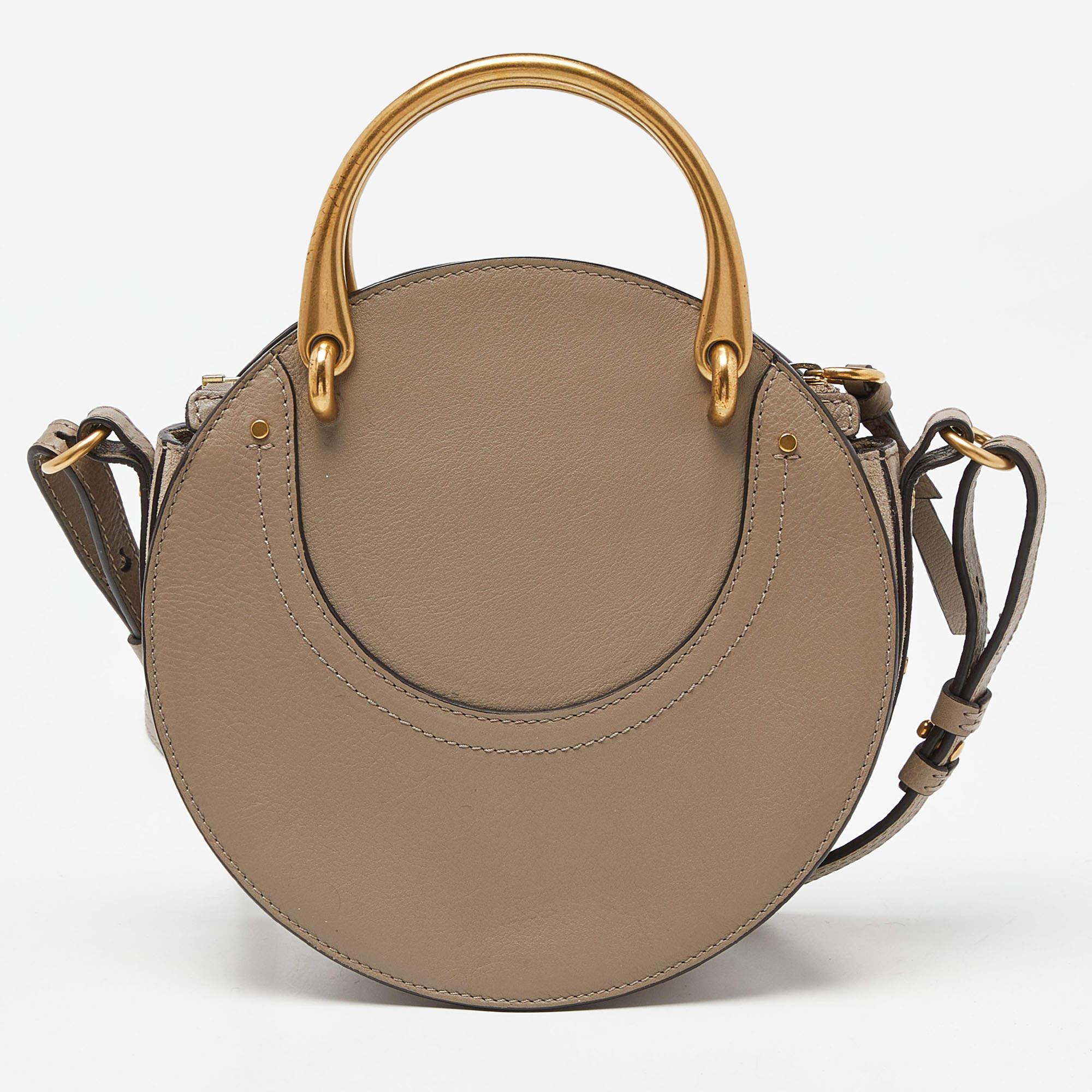 Give your totes and hobos a rest and opt for a light accessory when you're heading out, like this Pixie bag from Chloé! The leather & suede bag is compact and versatile in design. It has a round shape and it is held by two gold-tone handles that