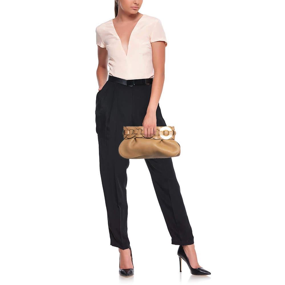 Die Darryl Clutch von Chloe ist ein elegantes Accessoire für jede Gelegenheit. Sie ist aus Leder gefertigt, und ein Besatz aus wiederholten kreisförmigen Ledermotiven ziert den oberen Teil des Designs. Der Innenraum ist so bemessen, dass alles