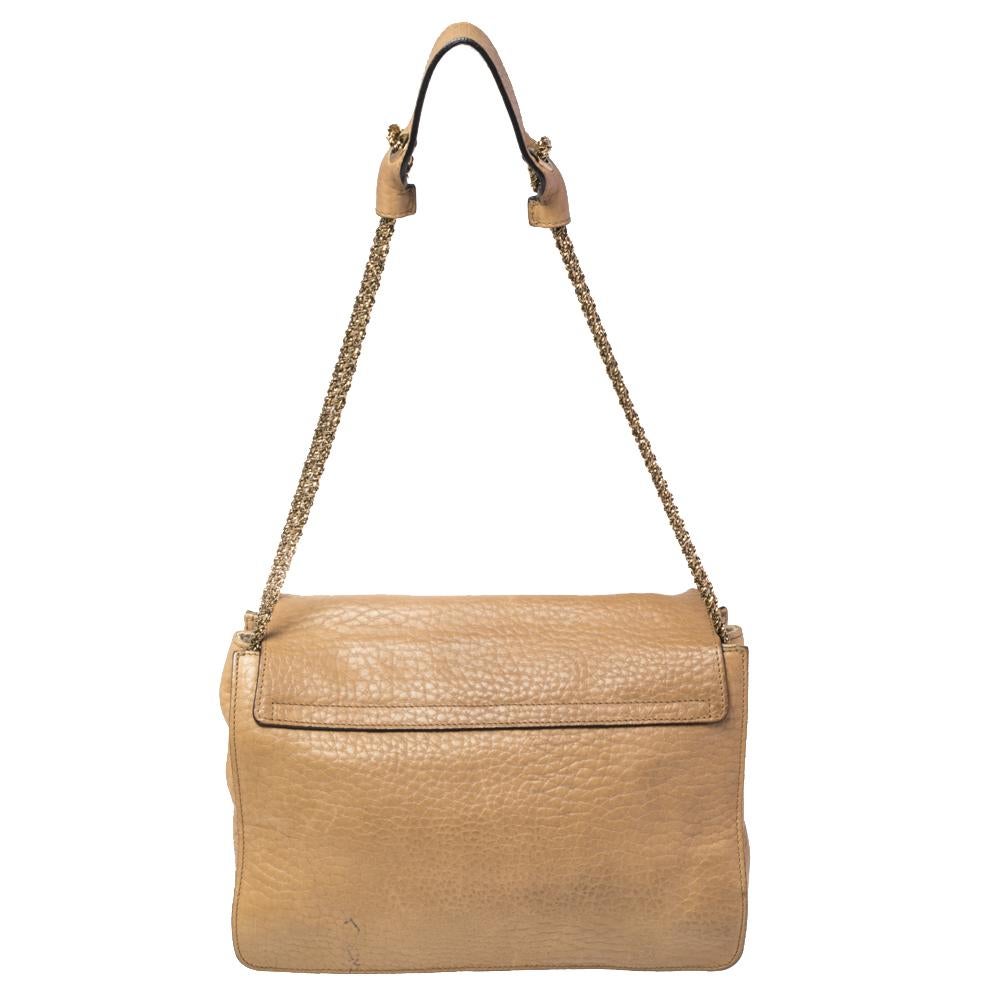 This stylish Sally shoulder bag from Chloé is crafted from beige-hued leather. The bag features a chain-link strap with a leather shoulder rest and a stunning flip-lock in gold-tone. The flap opens to a spacious fabric-lined interior that houses a