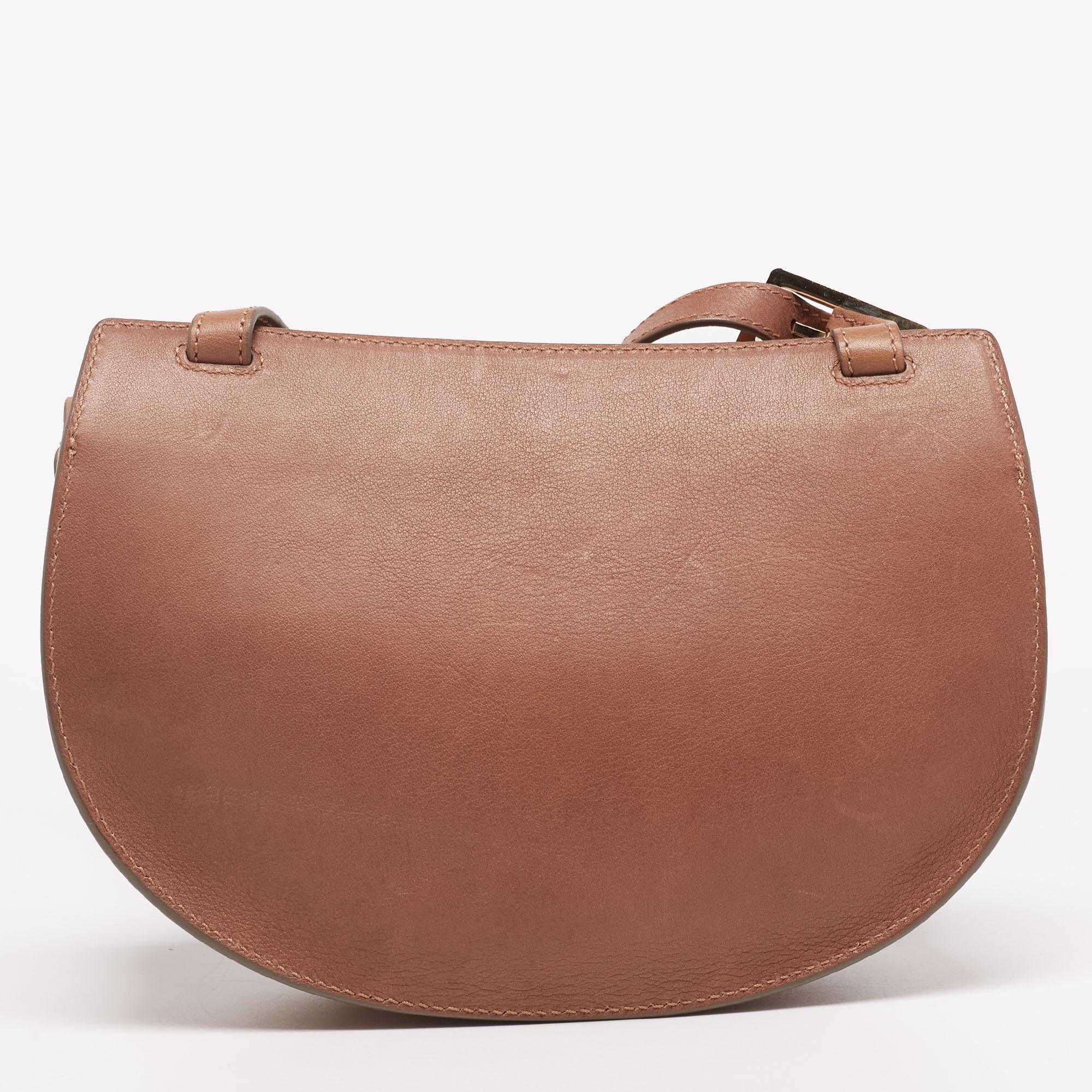 This stunning crossbody bag from Chloe is high in appeal and style. It is crafted from leather and is designed with a front flap that leads way to a spacious interior. The bag is held by a long shoulder strap. For those who love timeless pieces,