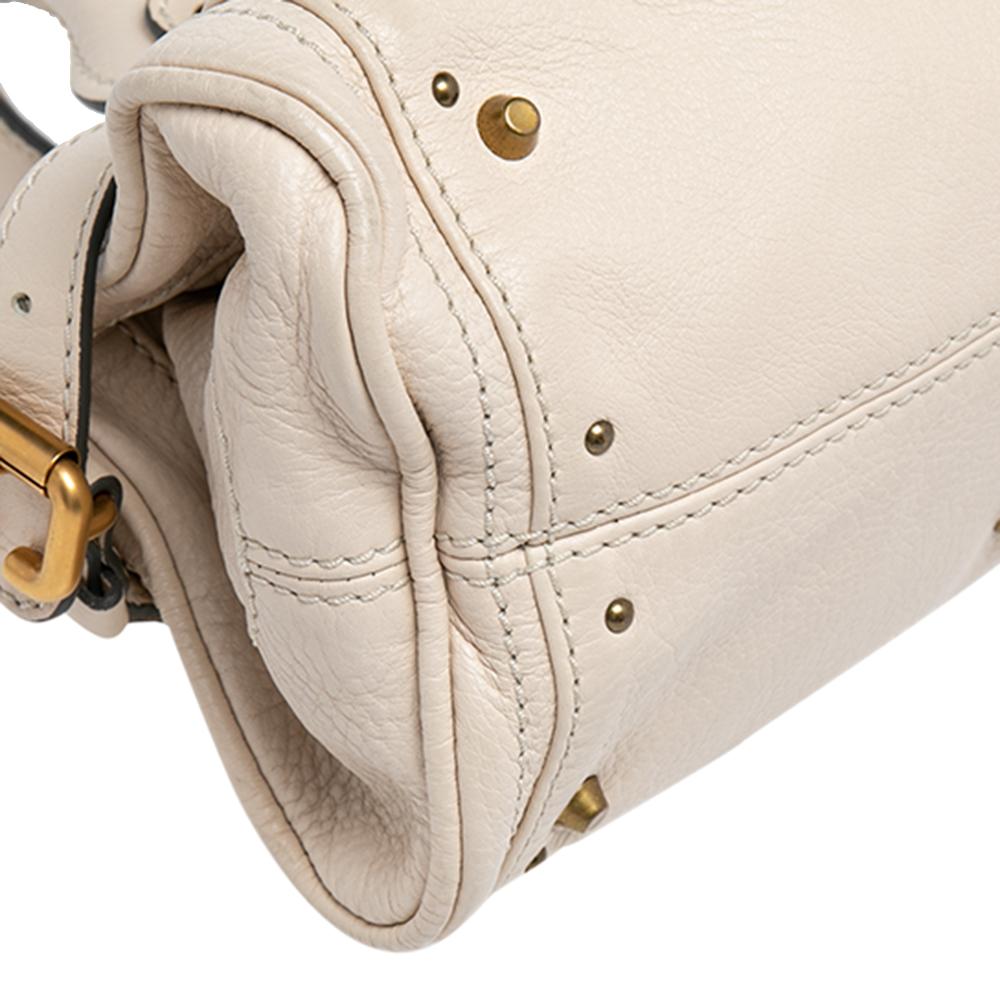 This Chloé Paddington bag is built to assist your impeccable style on all days. Gold-tone hardware with a chunky lock on the front easily attracts all the attention. The leather has an interesting texture while the canvas interior is sized to house