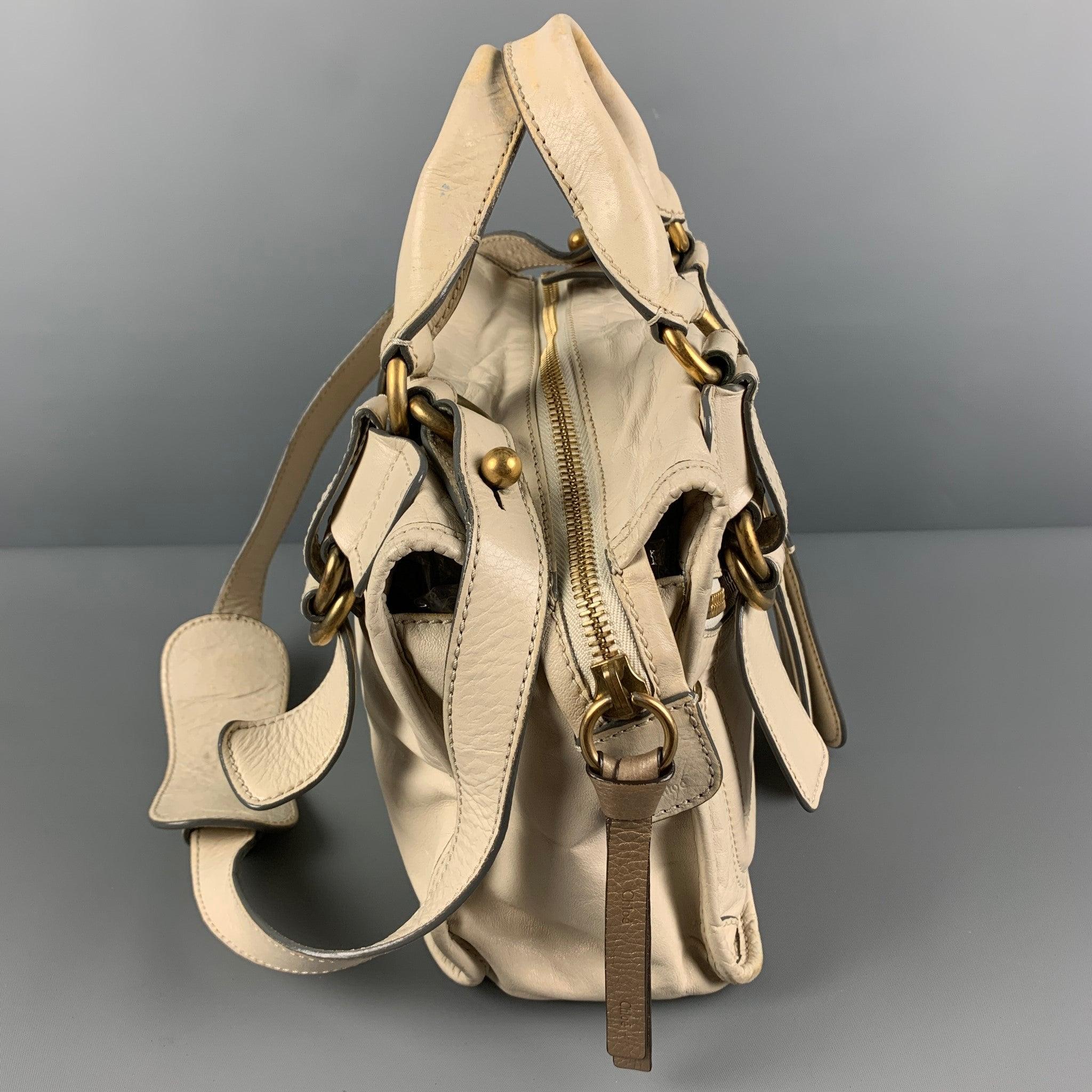 CHLOE bag comes in a beige leather featuring gold tone hardware, top handles, detachable shoulder straps, front pockets, inner pocket, and a top zipper closure. Made in Italy.
 Good
 Pre-Owned Condition. Moderate wear throughout. As-Is.  
 

