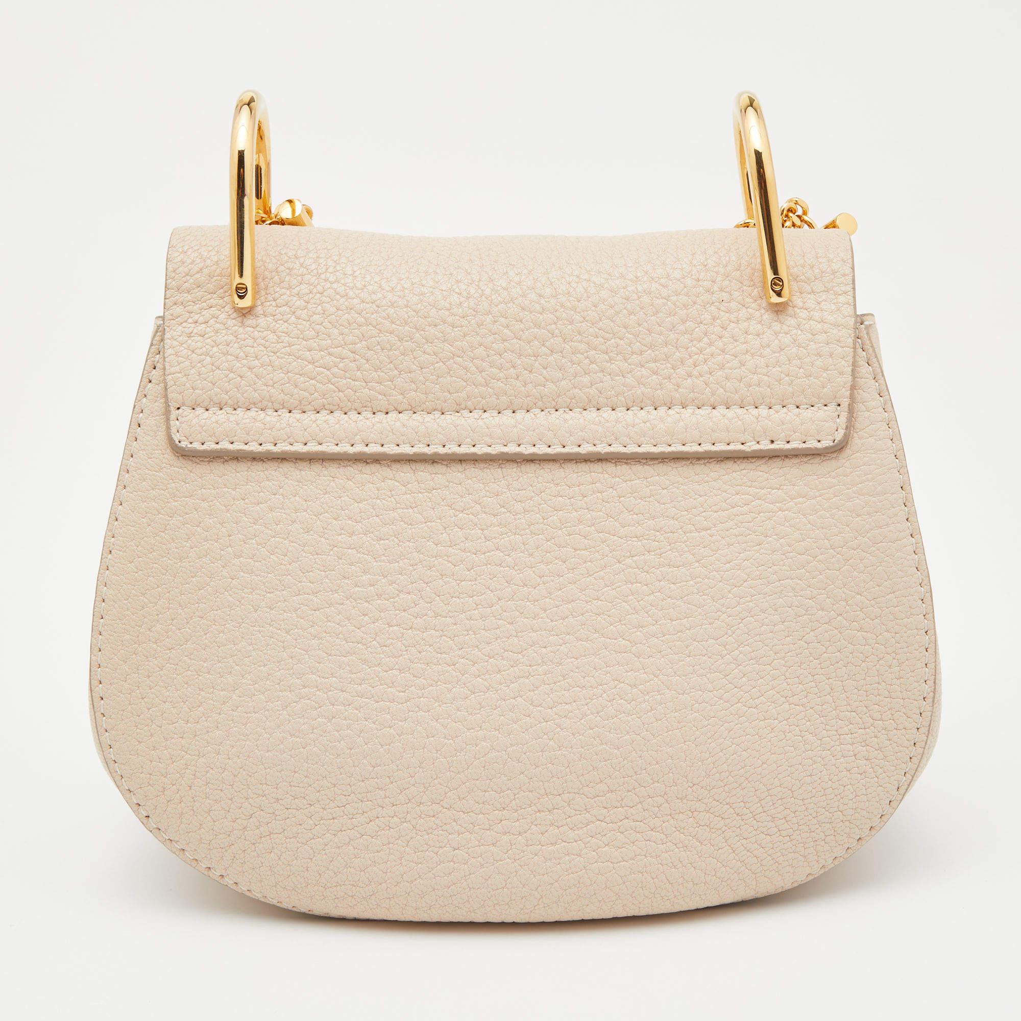 With its classic appeal and artistic design, this Chloe bag will win your heart at first sight. The gold-tone accents and luxurious elements of this beige creation make it a standout piece in your closet. Created from leather, it features a chain