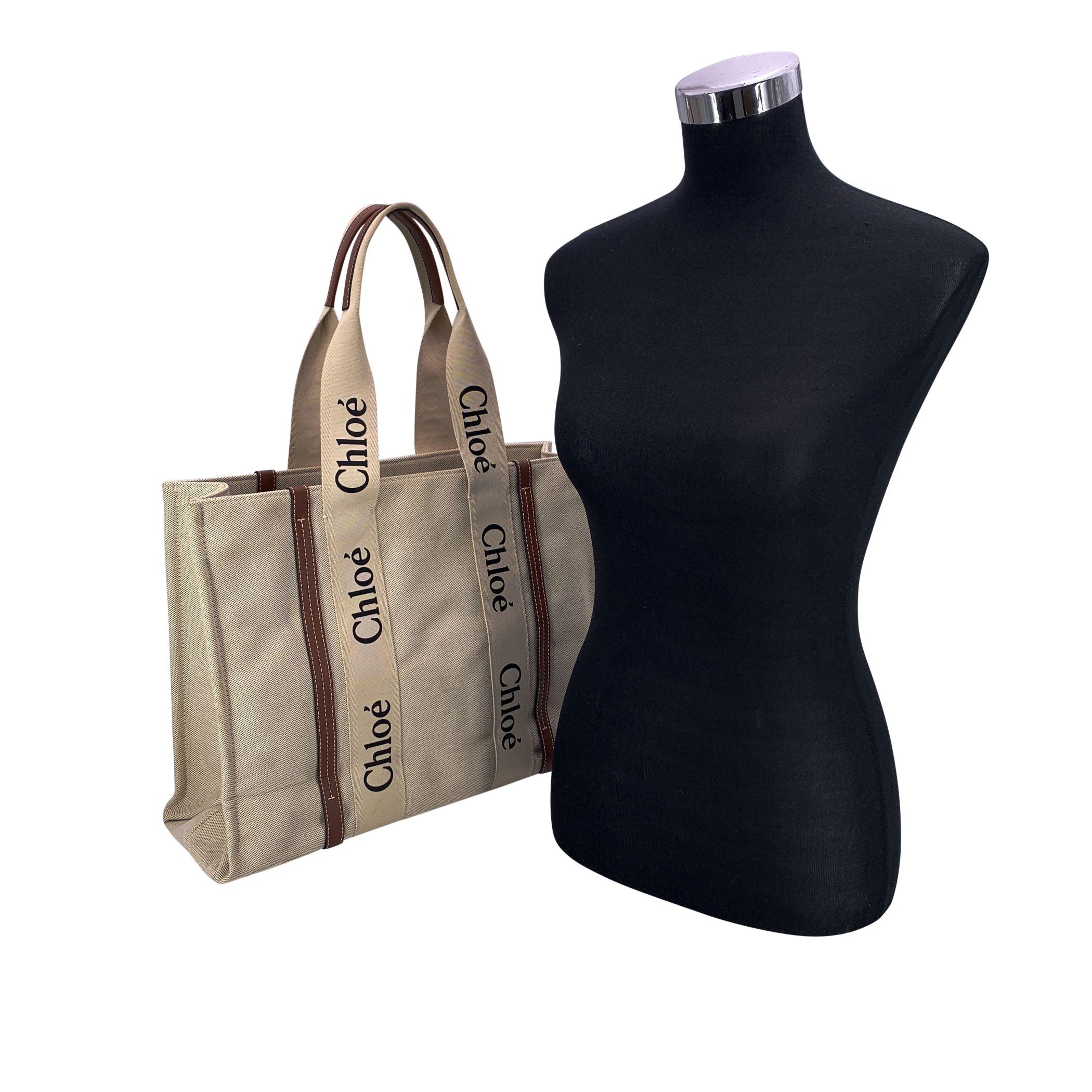 Die Chloé Woody Tote ist ein moderner Klassiker, der Pariser Eleganz und Alltagstauglichkeit in Einklang bringt. Sie ist mühelos schick und sofort erkennbar. Das Modell aus natürlichem Leinen und braunem Leder verkörpert den unaufdringlichen Luxus,