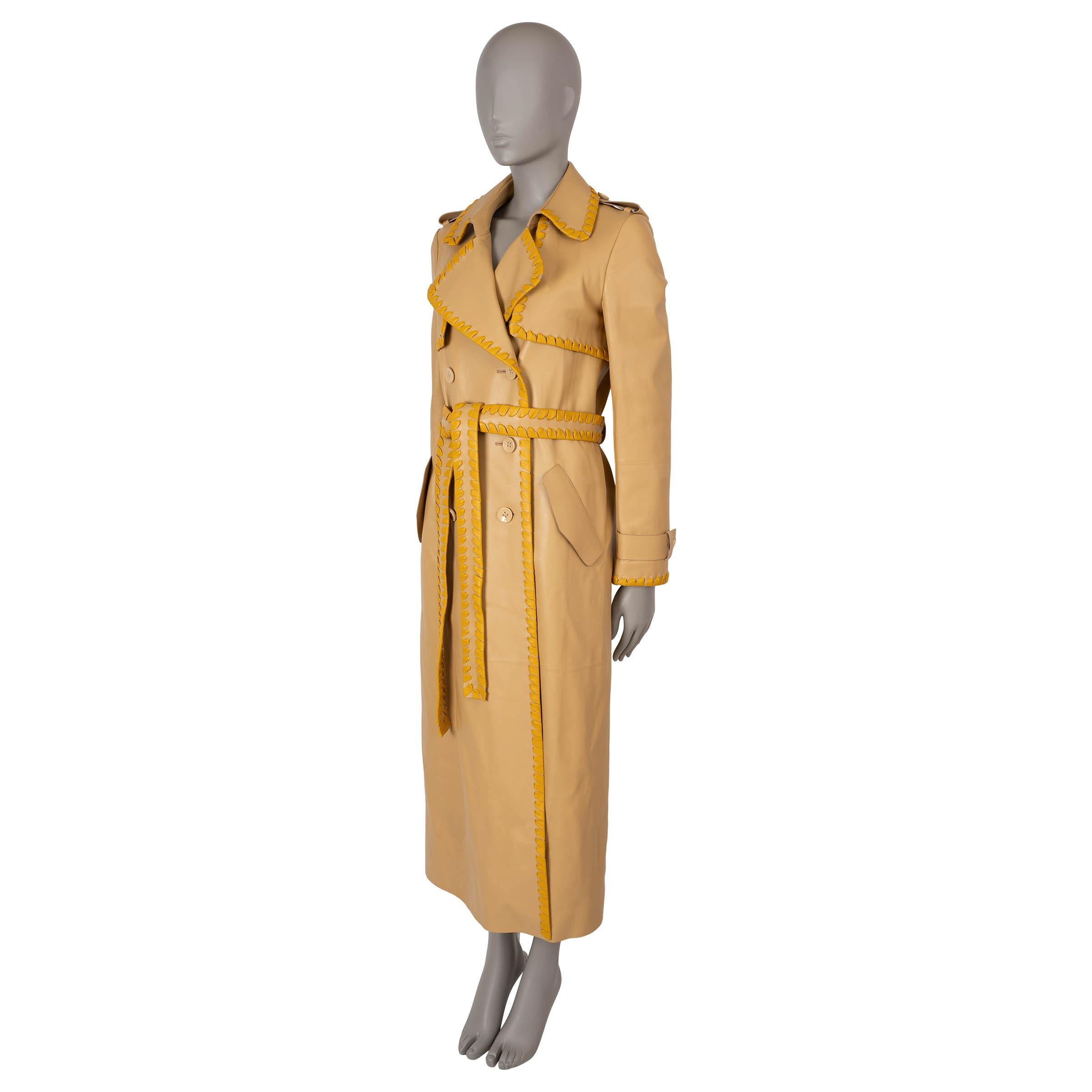 This 100% authentic Chloé trench coat in beige supple leather features exquisite mustard whipstitching along the edges for a unique touch. Classic details include epaulettes, notched lapels, storm flaps, belted cuffs, and two flap pockets. The coat