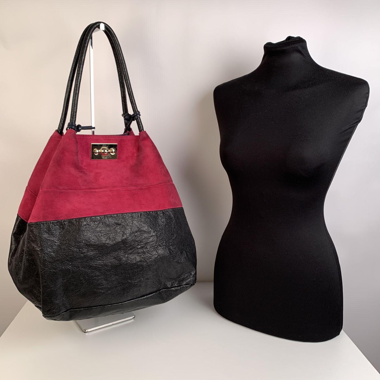 Large Chloe color block tote bag, crafted in black leather and magenta suede. Gold metal hardware. Double shoulder strap with tassels detailing. Front twist lock closure. The interior of the bag is in fabric with a zip pocket and an open pocket.