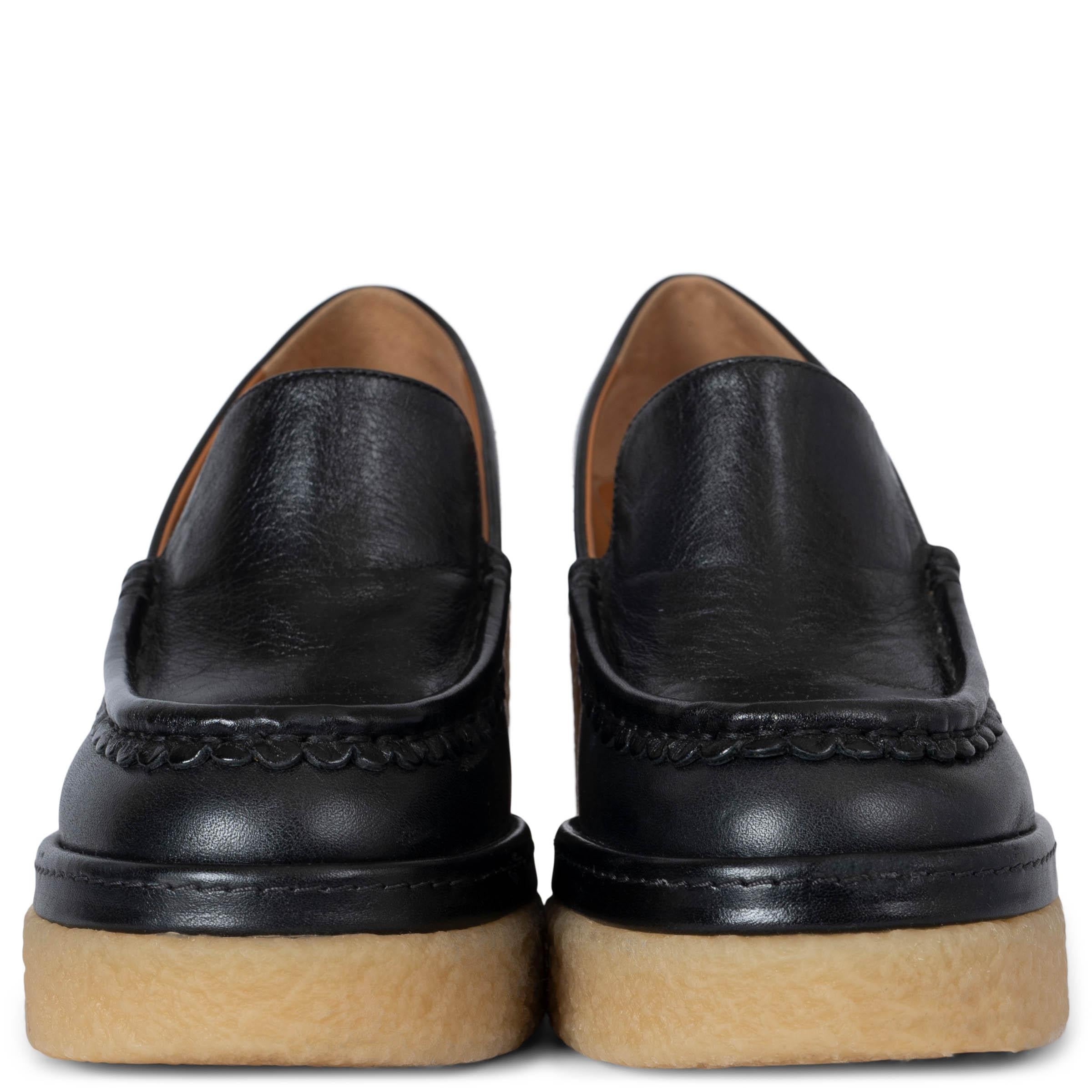 These 100% authentic buffed calfskin Chloé loafer-style heels are crafted in sleek black leather. Featuring elegant scalloped detailing at the round moc toe and a buffed calfskin tan lining, they exude sophistication. Set on a crêpe rubber block