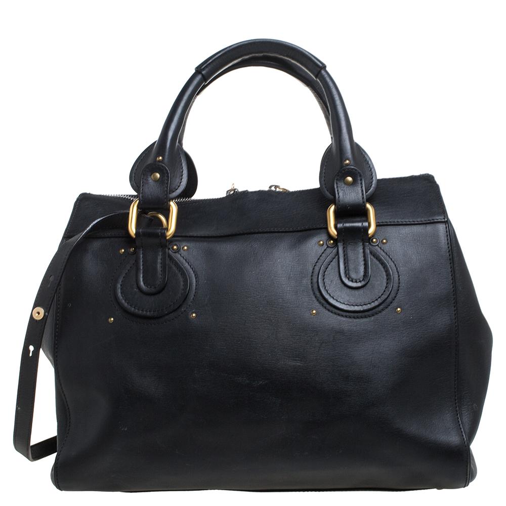 This Chloe Paddington tote is built to assist your impeccable style on all days. Gold-tone hardware with a chunky lock on the front easily attracts all the attention. The black leather has a fine finish and the fabric interior is sized to house your